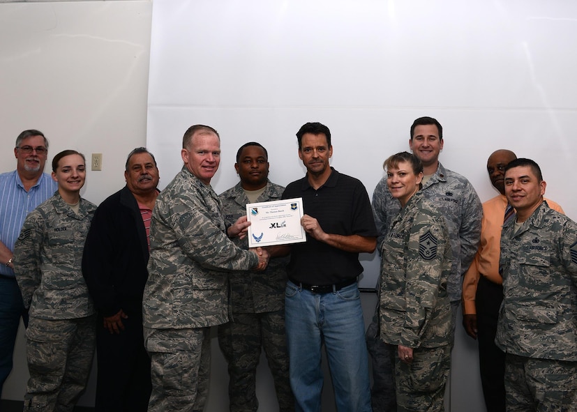 Thomas Busch, center, 47th Logistics Readiness Flight fuels management contracting officer’s representative, accepts the “XLer of the Week” award from Col. Darrell Judy, left, 47th Flying Training Wing vice commander, and Chief Master Sgt. Teresa Clapper, right, 47th FTW command chief, here, Feb. 10, 2016. The XLer is a weekly award chosen by wing leadership and is presented to those who consistently make outstanding contributions to their unit and Laughlin. (U.S. Air Force photo by Senior Airman Jimmie D. Pike)