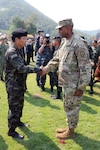 General Sommai Kaotira, the Chief of Defense Forces and Brigadier Gen. Gary M. Brito, Operations Deputy Commanding general for the 25th Infantry Division greet one another with a handshake during the Cobra Gold 16 opening ceremony Feb. 9, at the Royal Thai Marines Corps HQ, Sattahip Chonburi Province, Thailand. Cobra Gold is a Thai- U.S. co-sponsored exercise that represents the longstanding friendship between the Thai and American peoples.