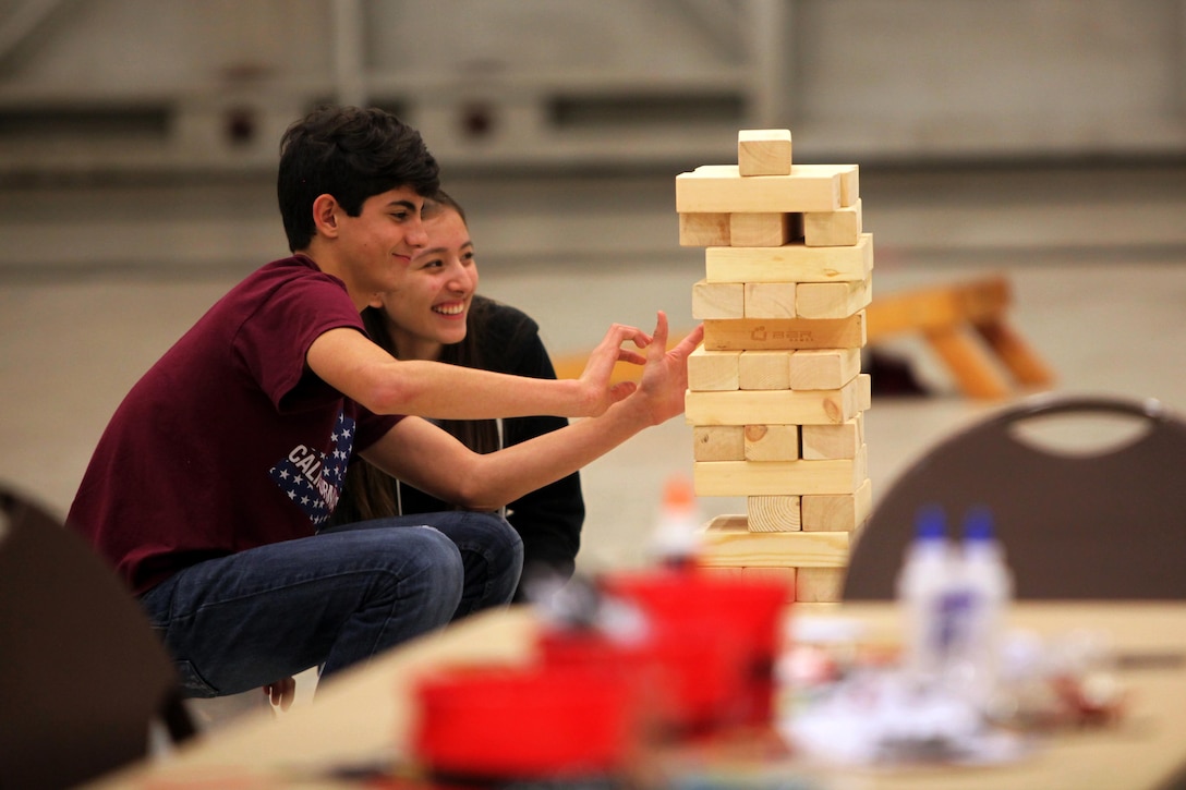 Caleb Passmore and Jasmin Tenorio play Jenga while attending the 7th annual Winter Wonderland at Marine Corps Air Station Cherry Point, N.C., Dec. 11, 2015. More than 700 Marines, Sailors and family members participate in the event. Winter Wonderland was hosted by Marine Aircraft Group 14 to foster camaraderie and increase esprit de corps within MAG-14 subordinate commands.
