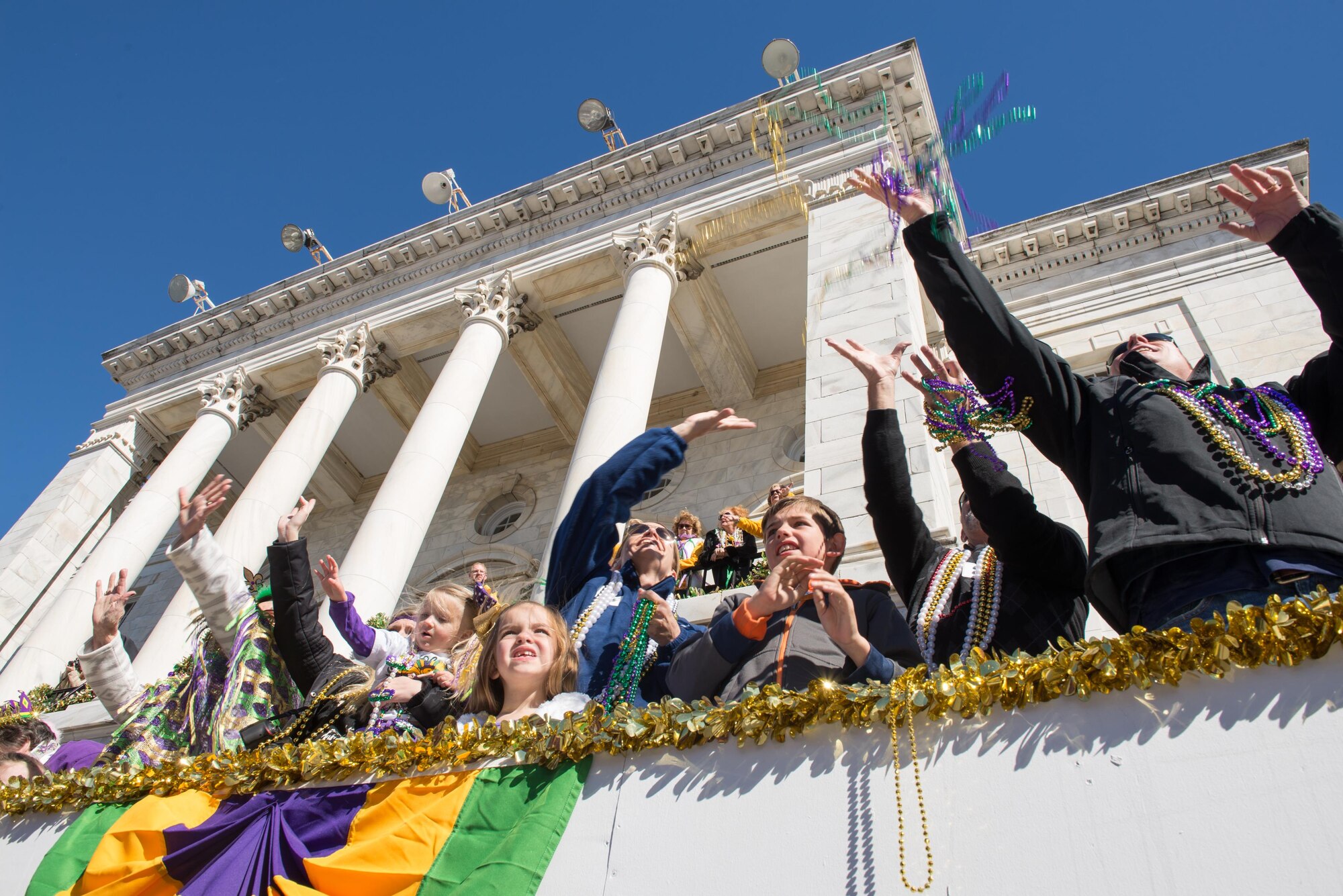 Col. Michele Edmondson, 81st Training Wing commander; her children, Jacqueline and Callahan, and her husband, Dave McGowan; and Col. Dennis Scarborough, 81st TRW vice commander; catch beads during the Gulf Coast Carnival Association Mardi Gras parade Feb. 9, 2016, Biloxi, Miss. The Keesler Honor Guard led the parade and other base leadership also attended the event. (U.S. Air Force photo by Marie Floyd) 