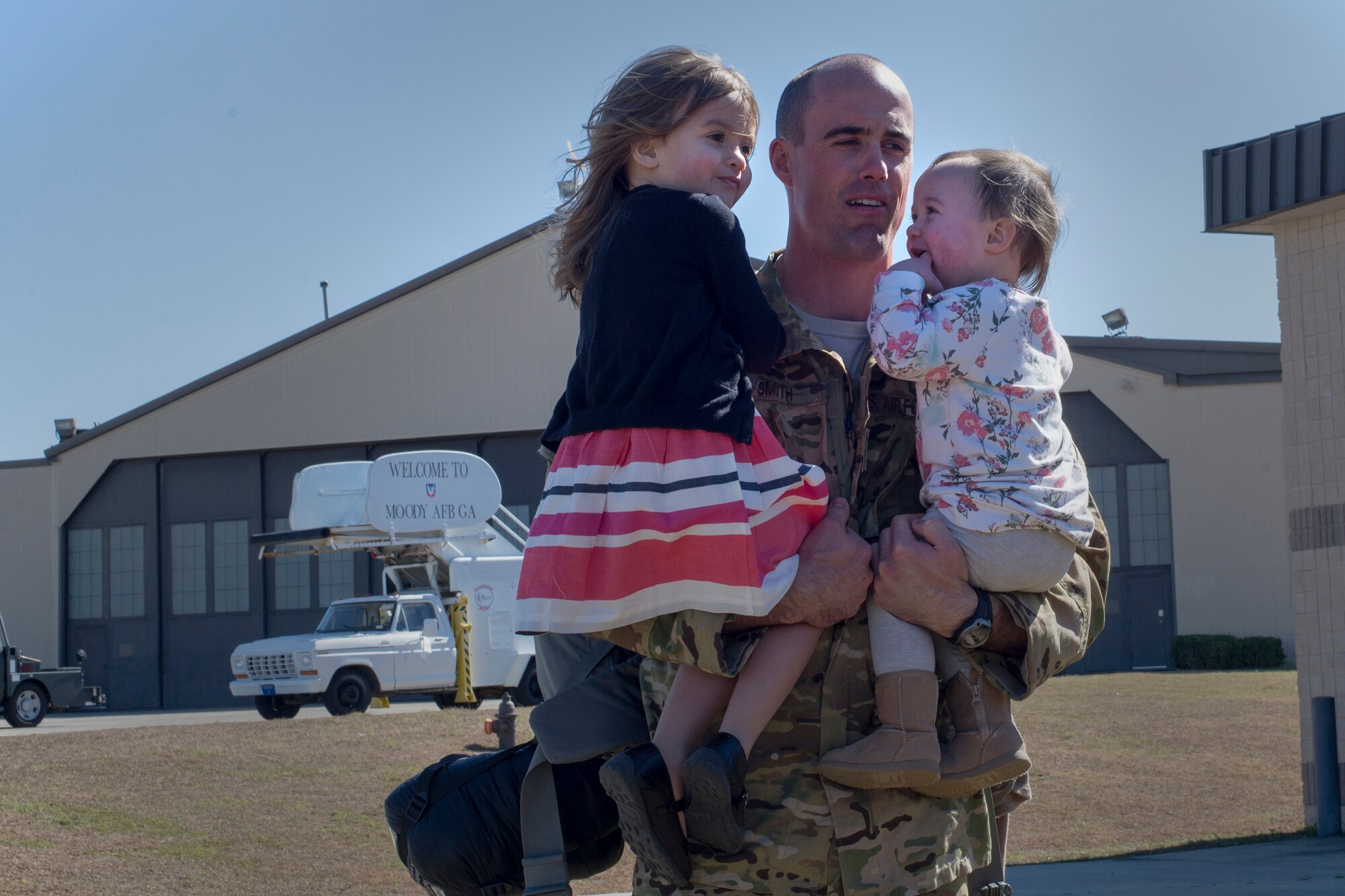 U.S. Air Force Capt. Robert Smith, 41st Rescue squadron pilot, holds his daughters, Ava and Macie, Feb. 10, 2016, at Moody Air Force Base, Ga. Airmen from the 41st RQS returned from Southwest Asia in support of combat search and rescue. (U.S. Air Force photo by Airman Daniel Snider/Released)