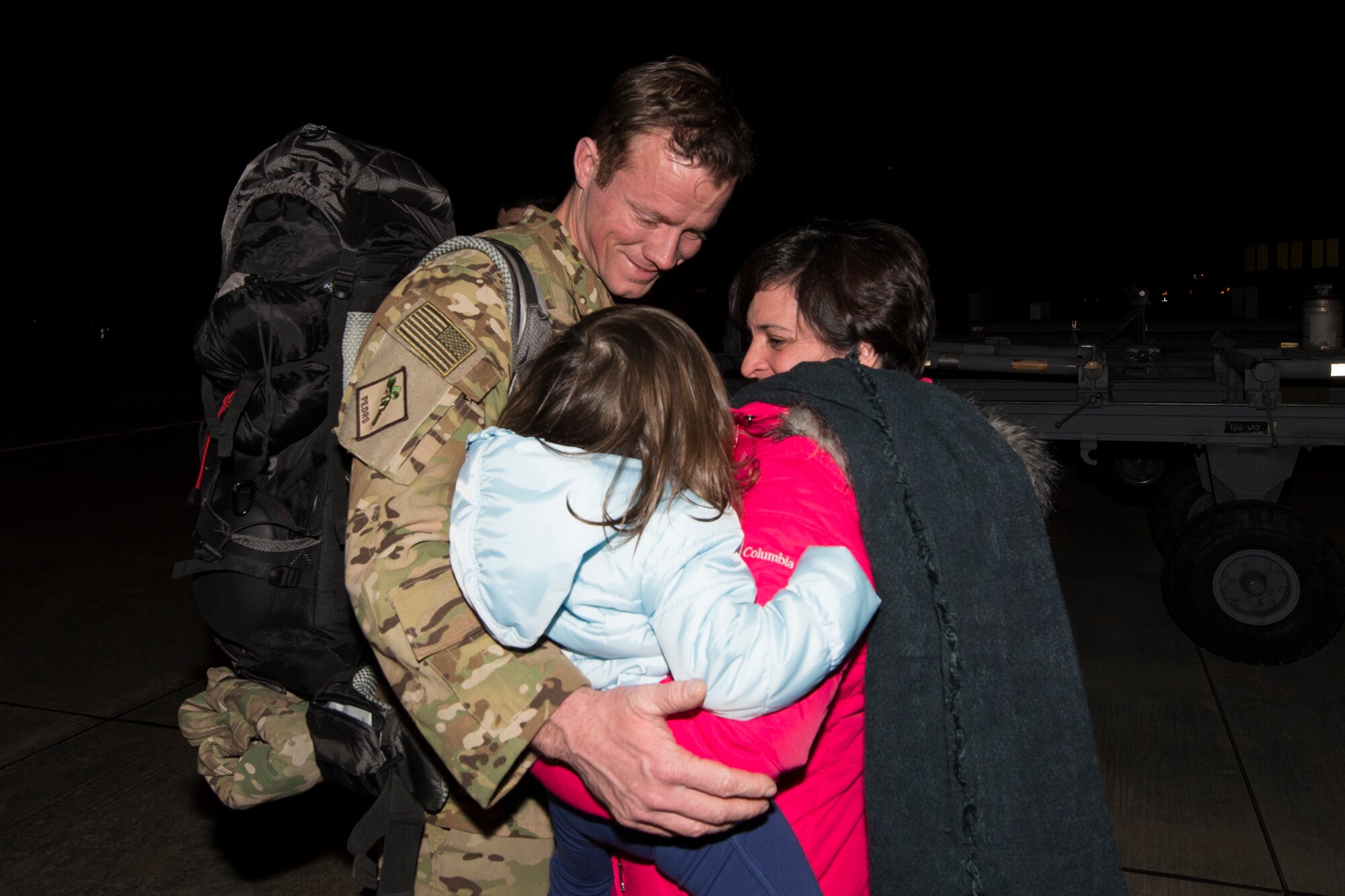 U.S. Air Force Tech. Sgt. Christopher Corbine, 41st Rescue Squadron special missions’ aviator, hugs his wife, Dominique, and their daughter after returning from a deployment, Feb. 10, 2016, at Moody Air Force Base, Ga. Airmen from the 41st RQS were deployed for approximately six months. (U.S. Air Force photo by Airman 1st Class Janiqua P. Robinson/Released)