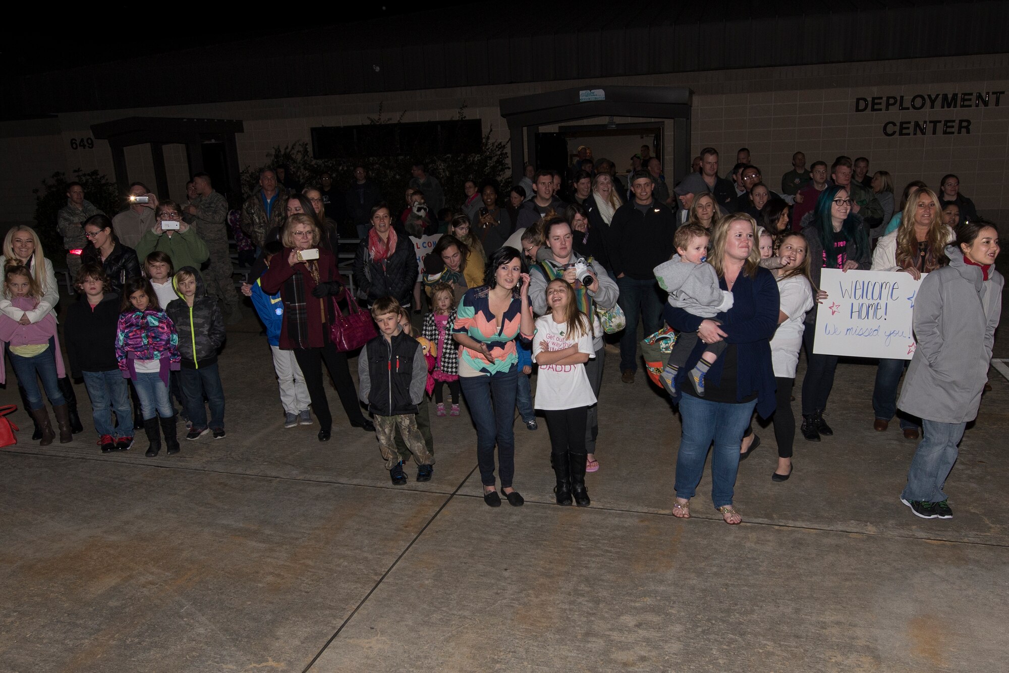 Family and friends wait for Airmen to exit a plane after a deployment, Feb. 10, 2016, at Moody Air Force Base, Ga. The 41st Rescue Squadron Airmen were greeted by family, friends and fellow co-workers when they returned. (U.S. Air Force photo by Airman 1st Class Janiqua P. Robinson/Released)