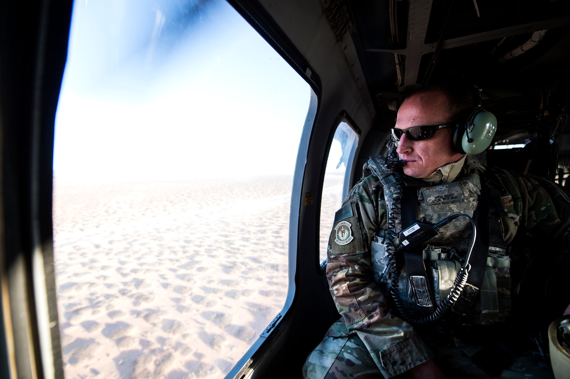 U.S. Air Force Lt. Col. Steve Raspet, 7th Air Support Operations Squadron commander, examines the sky inside of a U.S. Army Sikorsky UH-60 Black Hawk while traveling to the Oro Grande Training Complex for the joint exercise, Iron Focus, Feb. 4, 2016. Iron Focus is held at least twice a year dependent upon the rotation of each Army brigade. (U.S. Air Force photo by Senior Airman Olivia Dominique/Released)