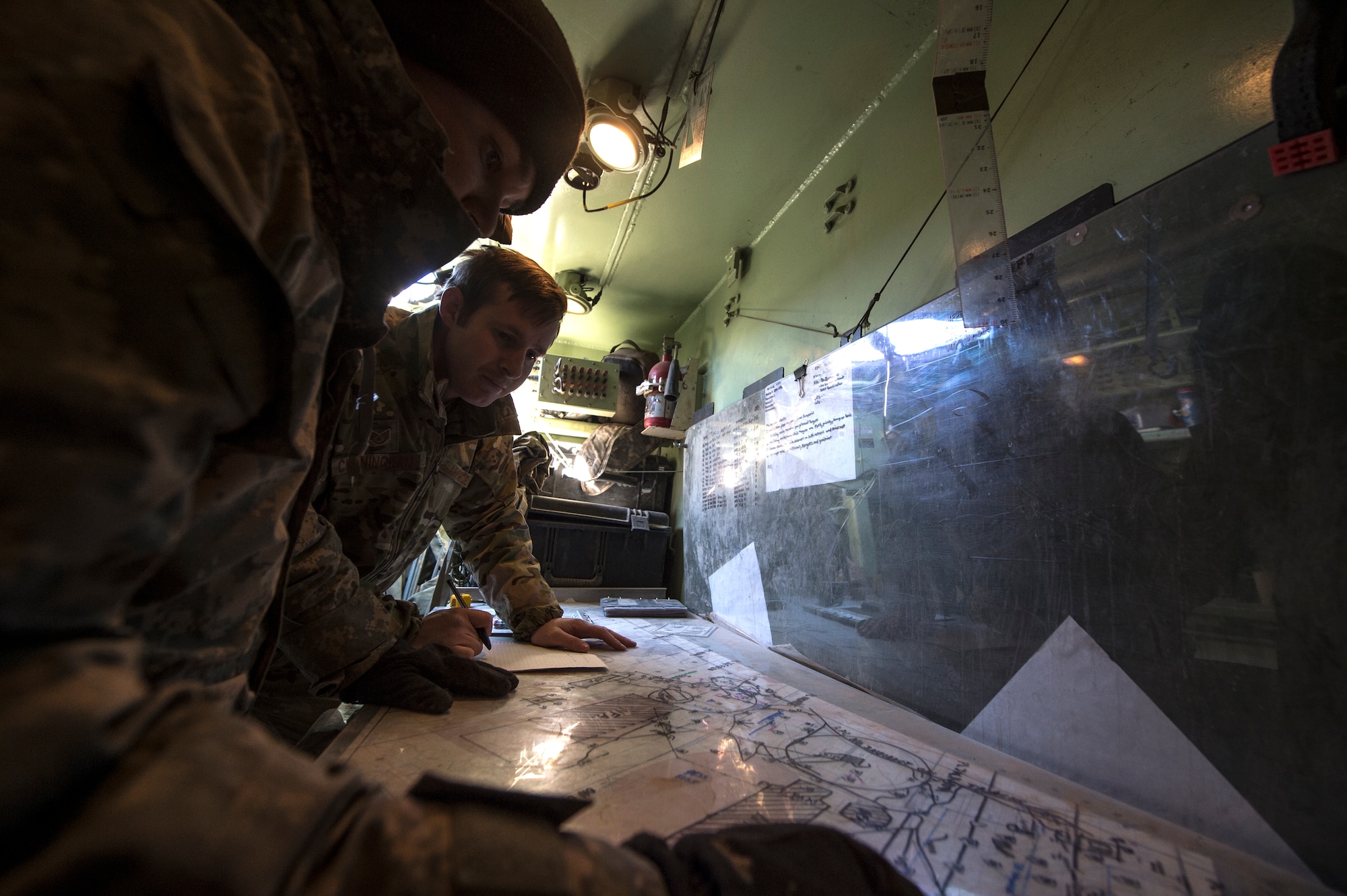 U.S. Army Capt. David Burkhardt, 3rd Brigade Combat Team, 1st Armored Division battalion fire support officer, left, and U.S. Air Force Staff Sgt. Lonny Cunningham, 7th Air Support Operations Squadron joint terminal attack controller, plan for operations during the joint exercise, Iron Focus, Feb. 3, 2016, at Oro Grande Training Complex at Fort Bliss, Texas. The exercise included various Air Force assets such as aircraft and weapons systems to assist Army counterparts in their ground maneuvers. (U.S. Air Force photo by Senior Airman Olivia Dominique/Released)