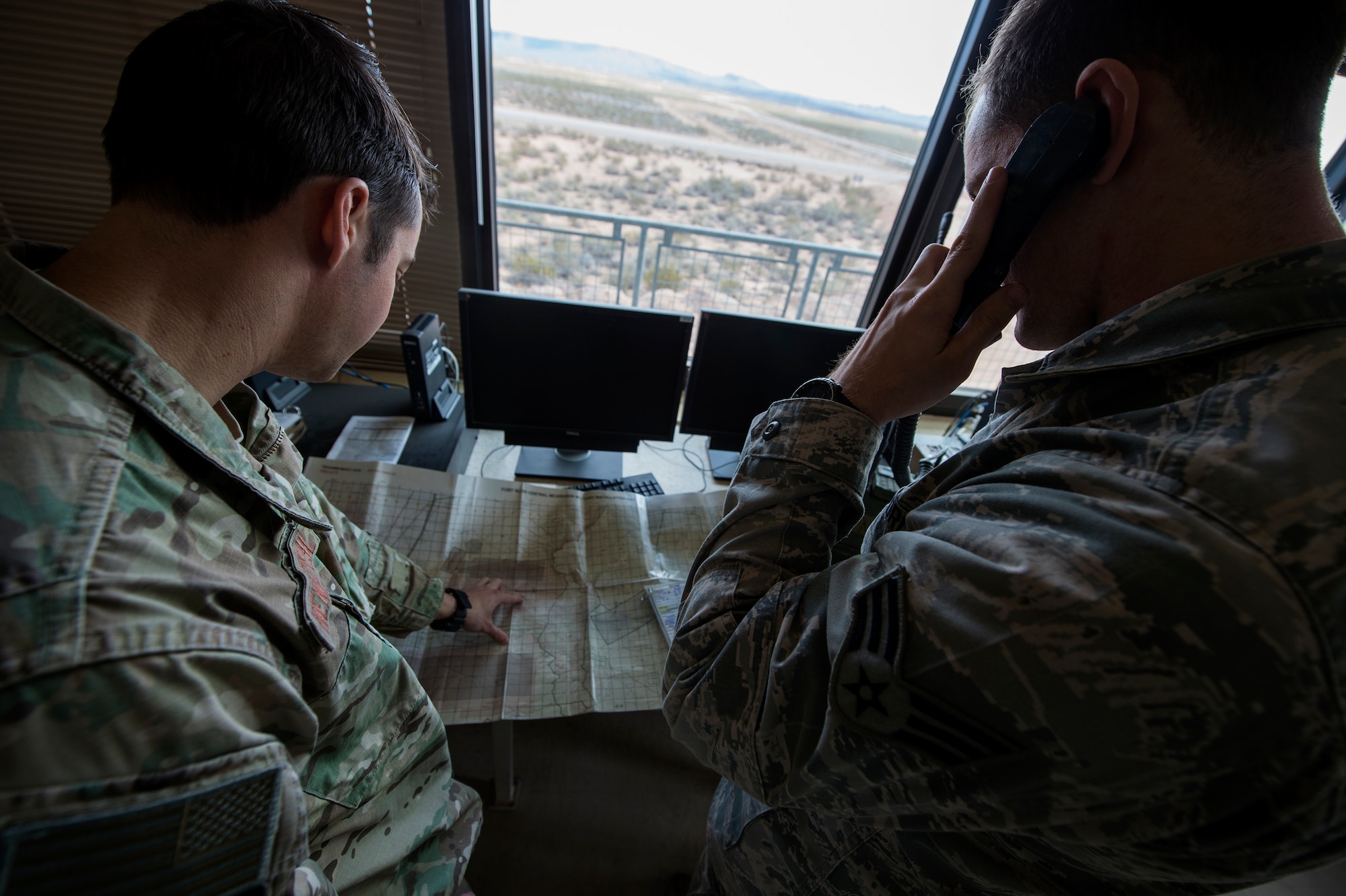 U.S. Air Force Staff Sgt. Derek Nennstiehl, left, and Senior Airman Jacob Mullen, 7th Air Support Operations Squadron joint terminal attack controllers, communicate with a B-52 Stratofortress pilot during the joint exercise, Iron Focus, Feb. 2, 2016, at the Oro Grande Training Complex at Fort Bliss, Texas. After receiving consent from JTACs, B-52 aircraft along with B-1B Lancers dropped live bombs on the range throughout the exercise. (U.S. Air Force photo by Senior Airman Olivia Dominique/Released)