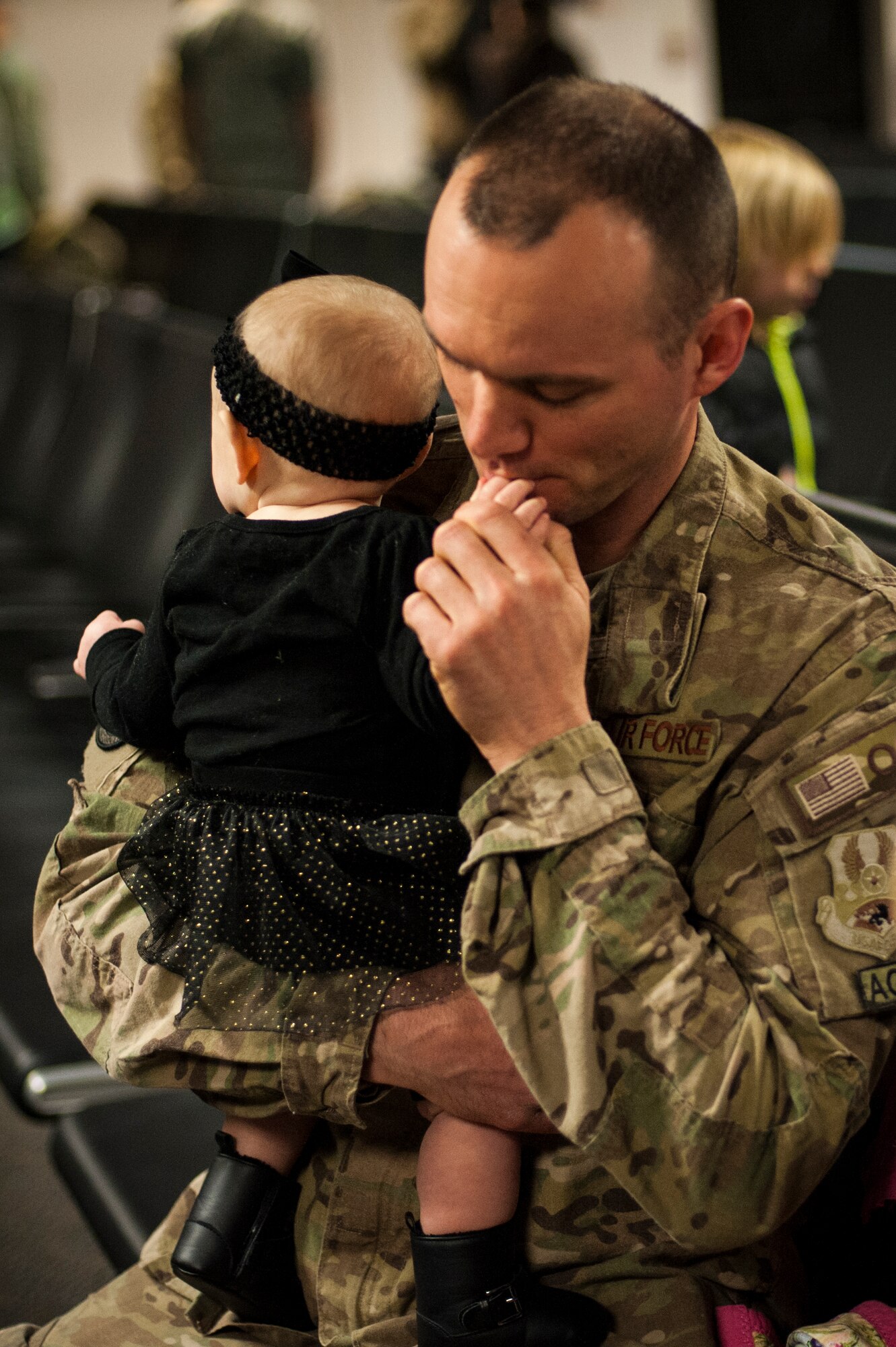 U.S. Air Force Staff Sgt. Richard Temple, 41st Rescue Squadron aerospace ground equipment craftsman, cuddles his daughter, Feb. 10, 2016, at Moody Air Force Base, Ga. Temple’s wife and three daughters greeted him upon his return home from deployment. (U.S. Air Force photo by Airman 1st Class Lauren M. Johnson/Released)