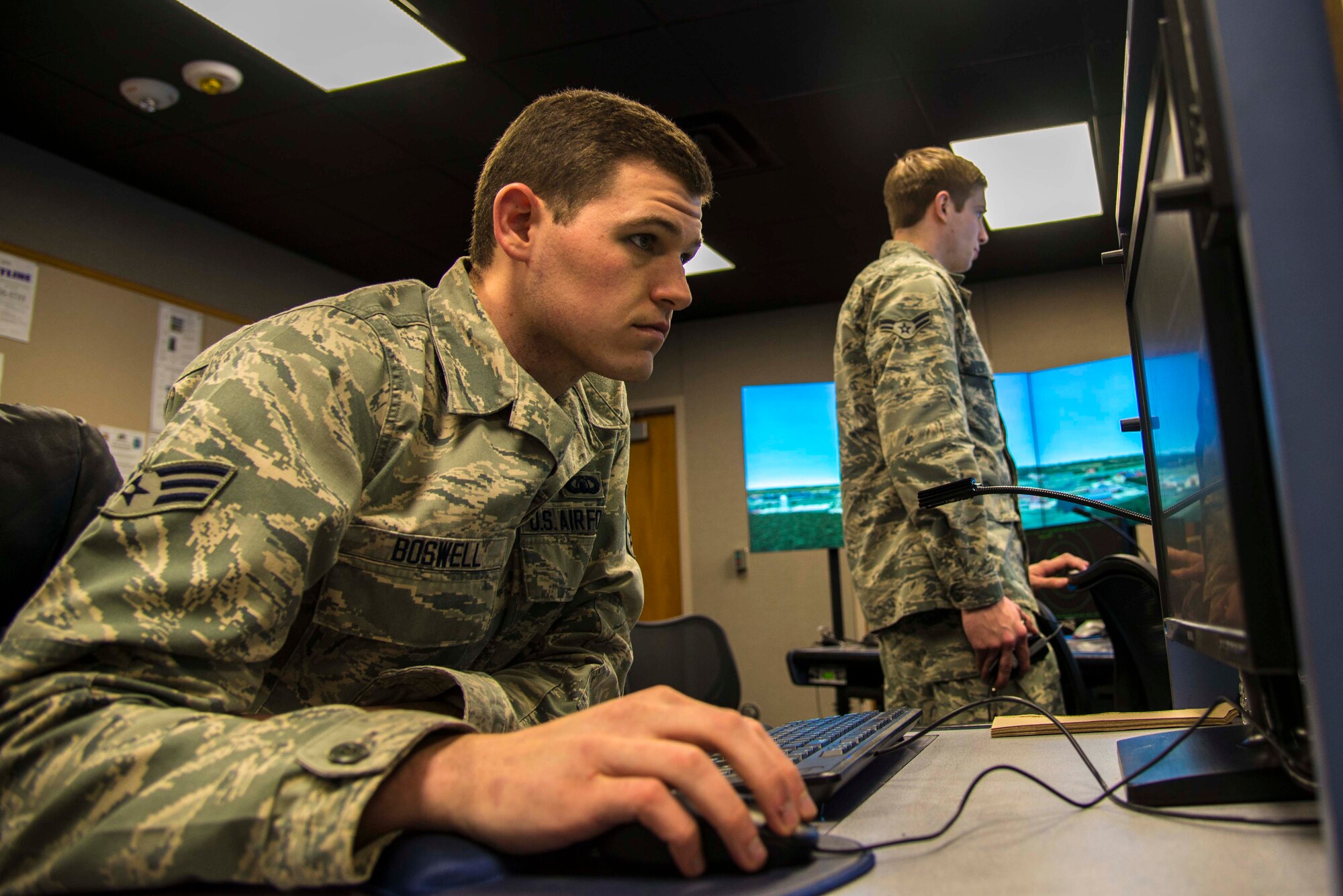 Senior Airman Cody Boswell, 375th Operations Support Squadron air traffic controller, monitors Airman 1st Class Christian Darr, 375th Operations Support Squadron air traffic control apprentice, during a simulated training exercise at the Scott Air Force Base air traffic control tower Feb. 5. The state-of-the –art simulator helps Airmen to practice a variety of situations in an electronic environment. (U.S. Air Force photo/Airman Daniel Garcia)