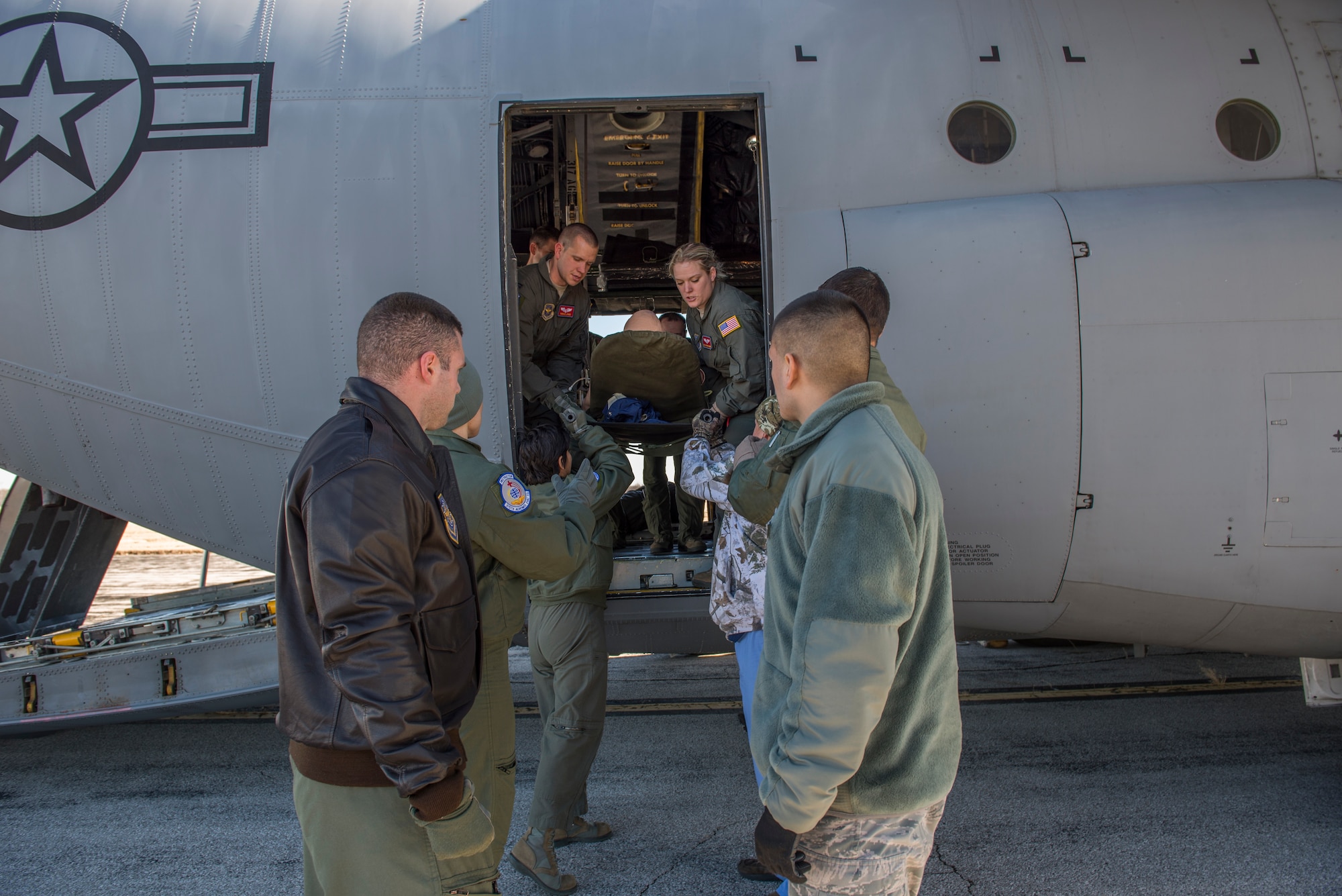 375th Aeromedical Evacuation Squadron Airmen perform emergency evacuation during training in a simulated C-130 Hercules fuselage Jan. 28, 2016, Scott Air Force Base, Illinois. The C-130 Hercules fuselage was rescued from the bone yard and is used to keep the aircrew's skills sharp. (U.S. Air Force photo by Airman 1st Class Melissa Estevez)