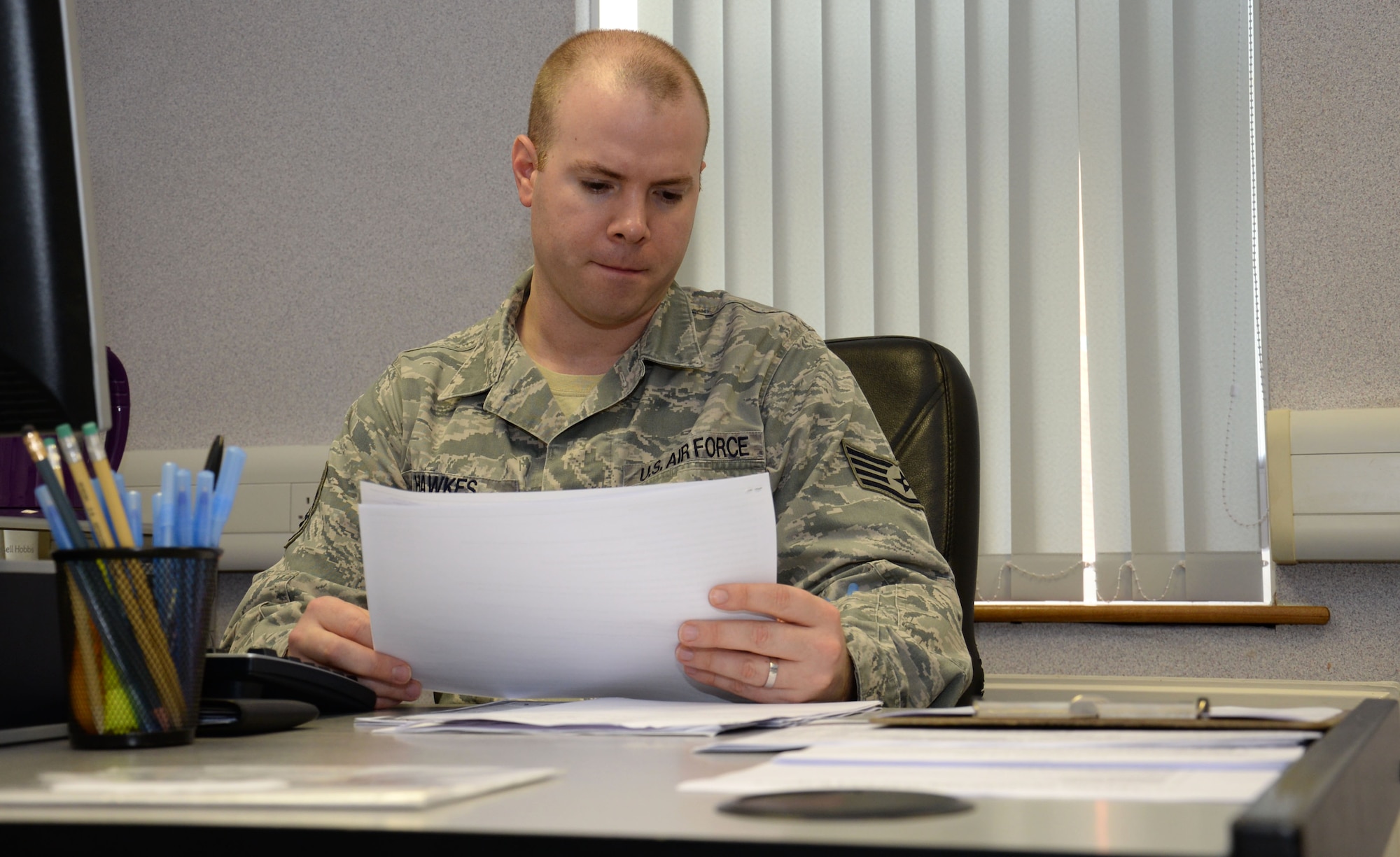 U.S. Air Force Staff Sgt. William Hawkes, 100th Air Refueling Wing NCO in charge of general and civil law, reviews intake sheets for tax preparation service Feb. 8, 2016, on RAF Mildenhall, England. Services provided by the tax center are free and open to all Department of Defense identification card holders with an annual income of $54,000 or less. (U.S. Air Force photo by Gina Randall/Released)
