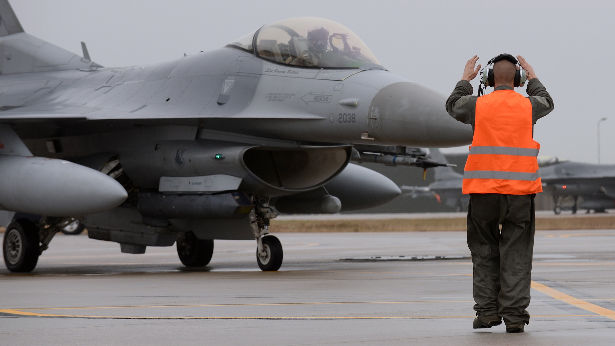 U.S. Air Force Senior Airman Andrew Burke, 31st Aircraft Maintenance Squadron dedicated crew chief, directs an F-16 Fighting Falcon for end-of-runway inspections before takeoff, Feb. 8, 2016, at Aviano Air Base, Italy. Team Aviano members must meet quarterly aircraft flying hours and adhere to the DUI Battle Plan to receive a wing goal day. (U.S. Air Force photo by Airman 1st Class Cary Smith/Released)