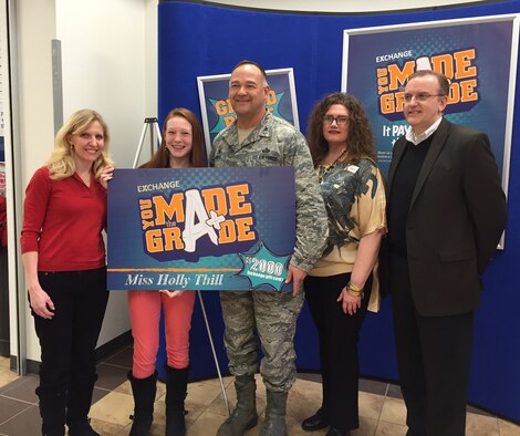 Holly Thill, second from left, is presented with a $2,000 prize Feb. 5 in the Army and Air Force Exchange Service’s worldwide “You Made the Grade” sweepstakes. The 14-year-old eighth-grader is choosing to spend part of her prize in purchasing Exchange items homeless people need and donate them to an area ministry. Her mother, Dr. Bridget Thill, far left, celebrates her daughter’s generosity along with Col. David Kretz, 88th Mission Support Group commander; and Exchange officials Christy Beenenga and Donald Walter Jr. (Skywrighter photos/Amy Rollins)