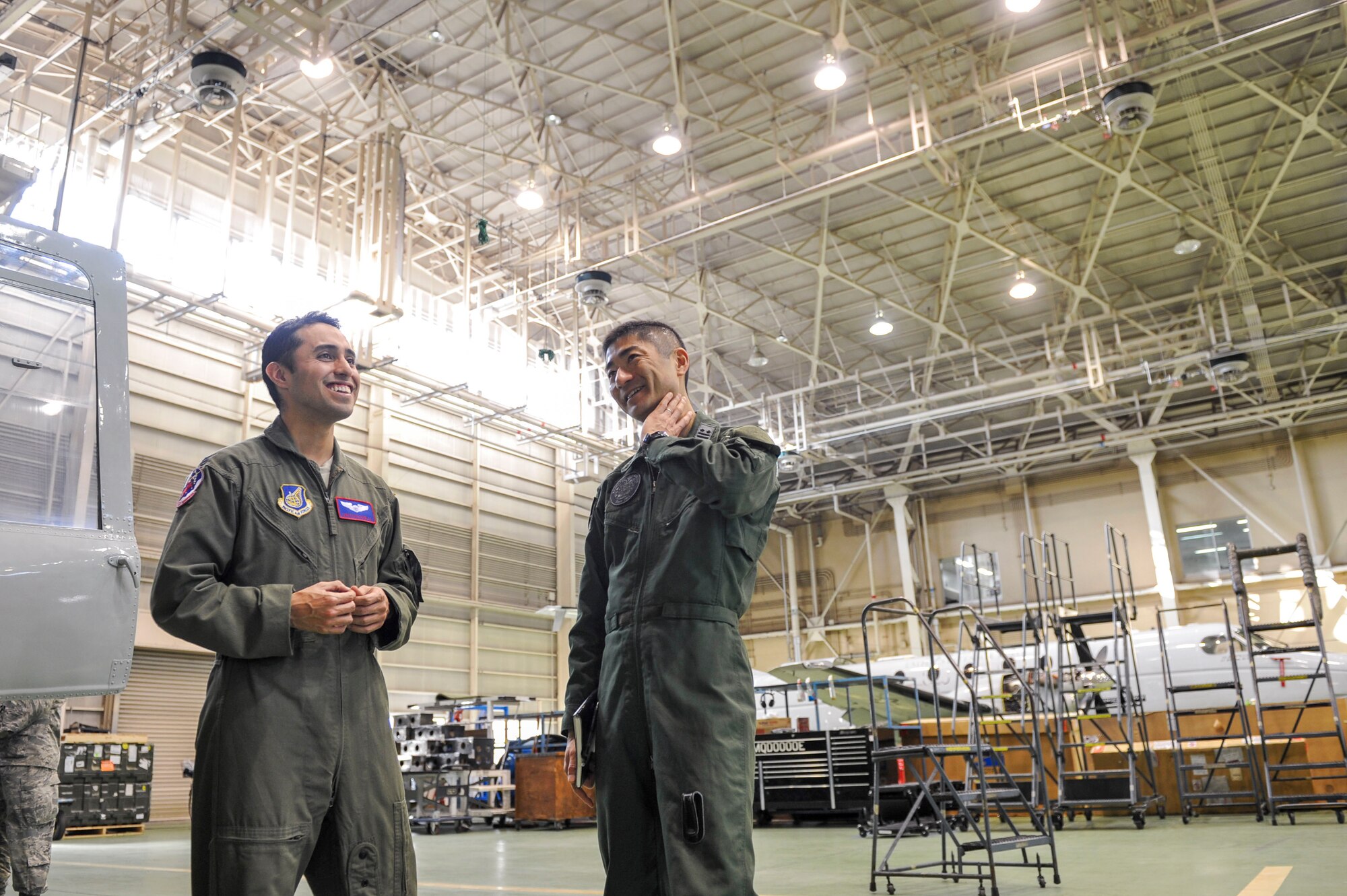 Capt. Jonathan Bonilla, 459th Airlift Squadron chief of training and UH-1N Huey pilot, left, and Japan Air Self-Defense Force Lt. Col. Hiroshi Kageura, Komatsu Air Rescue Squadron commander, discuss the capabilities of their respective units at Yokota Air Base, Japan, Feb. 9, 2016. The event was an opportunity for both services to learn the similarities and differences between their aircraft and search and rescue operations. (U.S. Air Force photo by Airman 1st Class Delano Scott/Released)