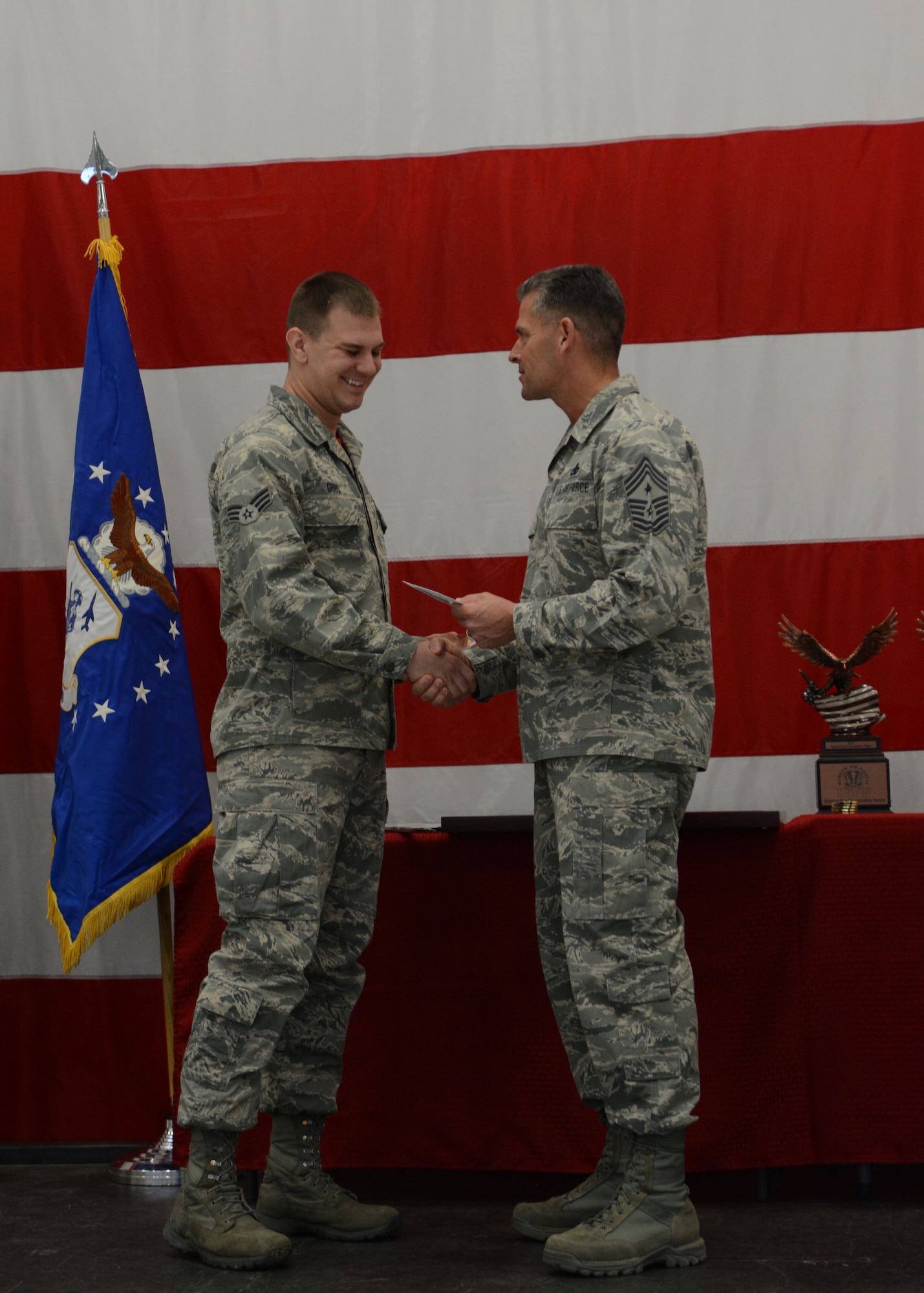 Senior Airman Troy Gibbs, 115th Fighter Wing operations group, accepts his Airman of the Year award from Chief Master Sgt. Thomas Safer, 115 FW command chief, during the first annual awards ceremony in Hangar 406 on Feb. 7, 2016. Several Airmen were recognized for their achievements during the ceremony. (U.S. Air National Guard photo by Staff Sgt. Andrea F. Rhode)