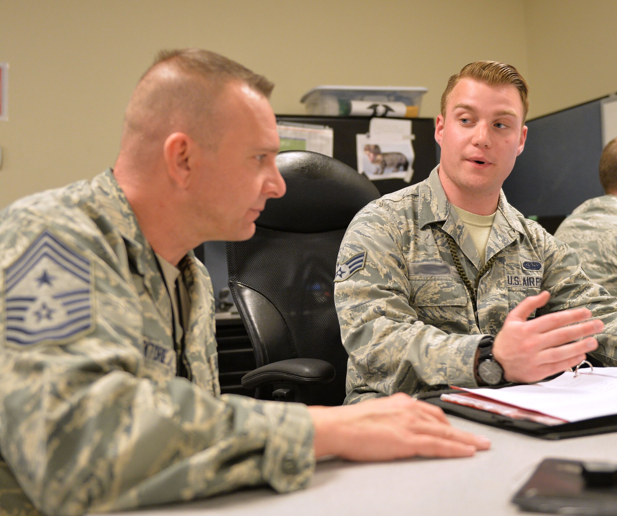 Chief Master Sgt. Michael Ditore, 432nd Wing/432nd Air Expeditionary Wing command chief, left, listens as Senior Airman Robert, 432nd Aircraft Communications Maintenance Squadron ground control station communications mechanic, explains how to fill out post-inspection paperwork Feb. 11, 2016, at Creech Air Force Base, Nevada. As a part of the communications squadron, Cameron is responsible for performing inspections on the ground control station. (U.S. Air Force photo by Senior Airman Christian Clausen/Released)

