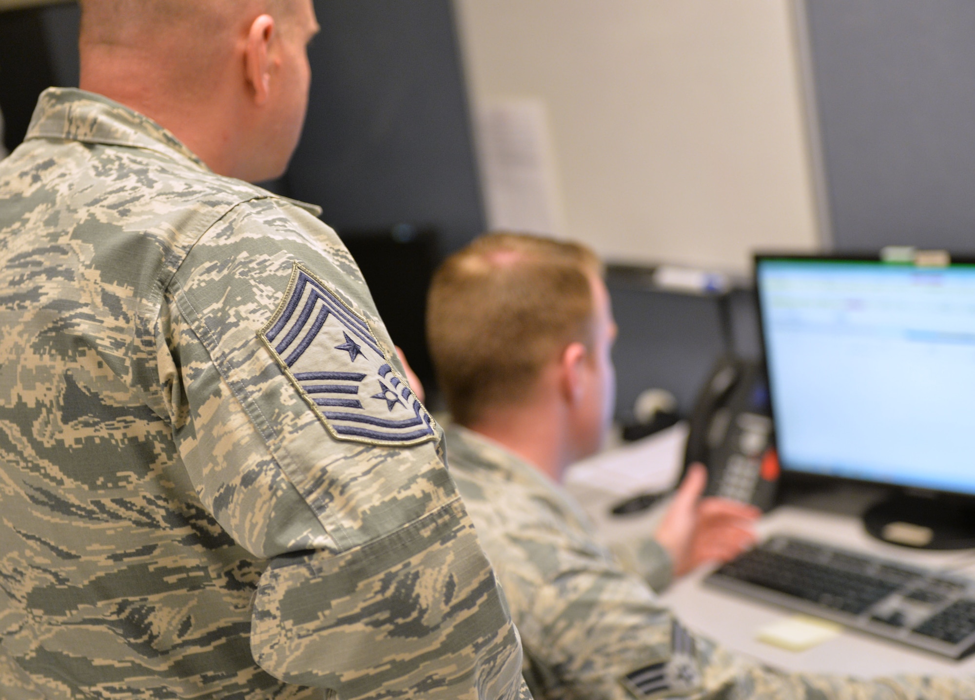 Chief Master Sgt. Michael Ditore, 432nd Wing/432nd Air Expeditionary Wing command chief, left, listens as Senior Airman Robert, 432nd Aircraft Communications Maintenance Squadron ground control station communications mechanic, explains how to fill out post-inspection paperwork Feb. 11, 2016, at Creech Air Force Base, Nevada. As a part of the communications squadron, Cameron is responsible for performing inspections on the ground control station. (U.S. Air Force photo by Senior Airman Christian Clausen/Released)