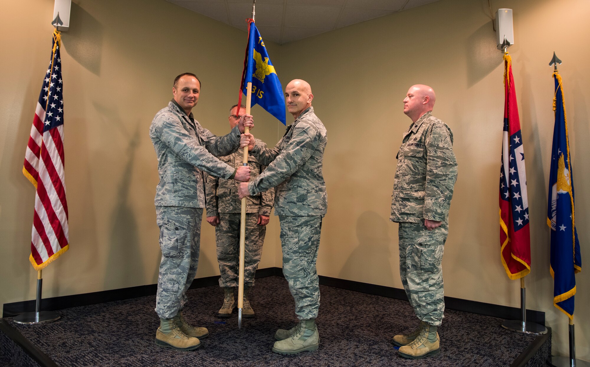 Col. Robert Kenny, commander of the 188th Intelligence, Surveillance and Reconnaissance Group, hands the guidon to Lt. Col. Robert Novak, commander of the 123rd Intelligence Squadron, Feb. 11, 2016 during a change of command ceremony at Ebbing Air National Guard Base, Fort Smith, Ark. Lt. Col. Sonny Stefancic, right, relinquished command of the 123rd IS to Novak and is now the deputy commander of the 188th ISRG. (U.S. Air National Guard photo by Senior Airman Cody Martin/Released)