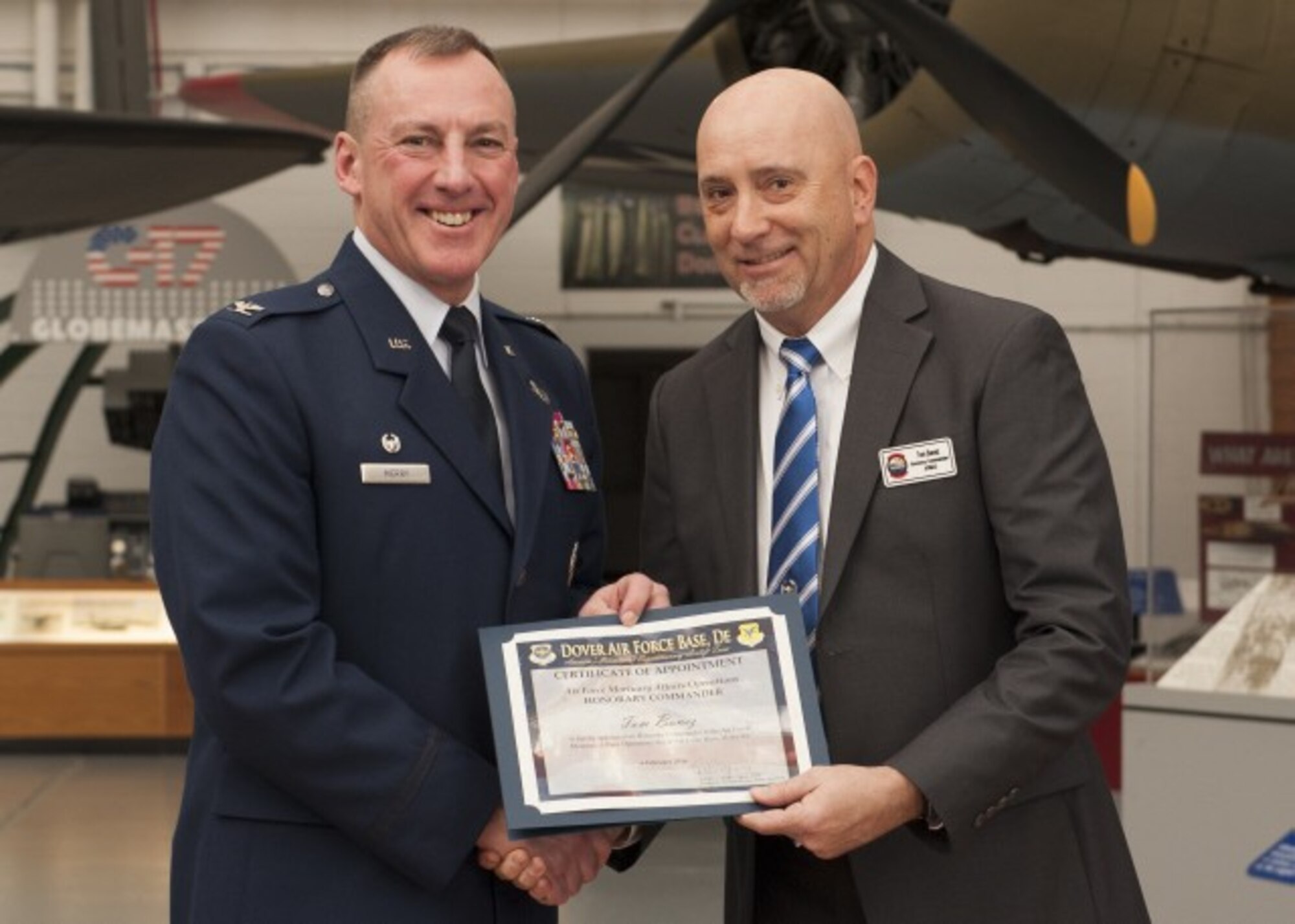 Col. Dan Merry, Air Force Mortuary Affairs Operations commander, presents Tom Banez, a certificate during the Honorary Commander Induction Ceremony Feb. 6, 2015 at the Air Mobility Command Museum. Banez, an engineer with the Delaware Department of Transportation, is the new honorary commander for AFMAO. (U.S. Air Force photo/Senior Airman Zachary Cacicia)