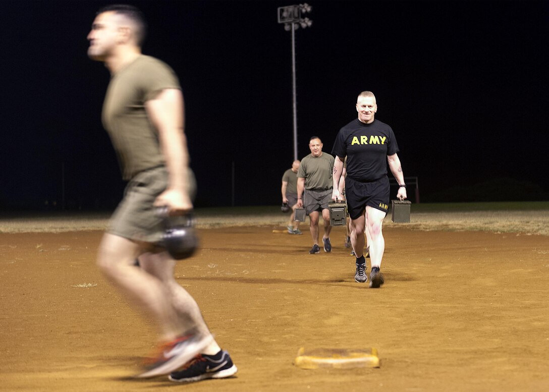 Army Command Sgt. Maj. John W. Troxell, right, senior enlisted advisor to the chairman of the Joint Chiefs of Staff, carries ammo cans during a morning physical training session with sailors and Marines at Camp H.M. Smith, Hawaii, Feb. 10, 2016. DoD photo by Navy Petty Officer 2nd Class Dominique A. Pineiro