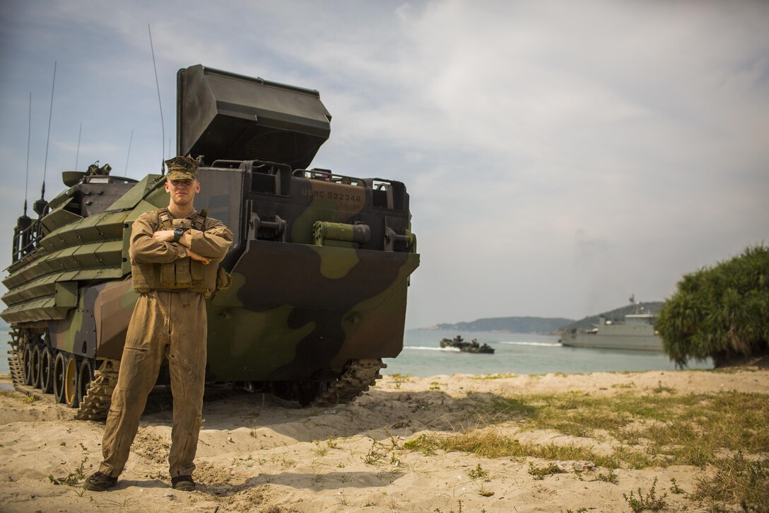 U.S. Marine Corps Lance Cpl. Jacob Irland, assault amphibious vehicle crewmember with 1st Battalion, 5th Marines, poses for photograph after an amphibious capabilities demonstration at Hat Yao, Rayong, Thailand, during exercise Cobra Gold, Feb. 12, 2016. Cobra Gold is a multinational training exercise developed to strengthen security and interoperability between the Kingdom of Thailand, the U.S. and other participating nations. 