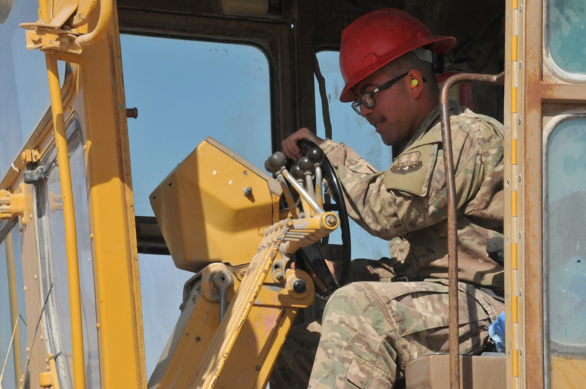 Senior Airman Roman Fulgenzi, 557th Rapid Engineer Deployable Heavy Operational Repair Squadron Engineer heavy equipment operator drives a grader Jan. 30 at Al Udeid Air Base, Qatar. Fulgenzi uses the grader to level out the ground to prevent the taxiway from flooding. Fulgenzi, a guardsman, is deployed from the 210th RHS, Kirtland Air Force Base, New Mexico. He has been part of the RED HORSE squadron for three years. (U.S. Air Force photo by Tech. Sgt. Terrica Y. Jones/Released)