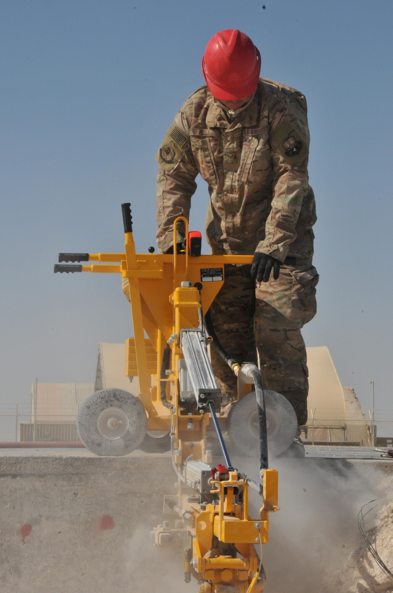 Senior Airman Shawn Polk, 557th Rapid Engineer Deployable Heavy Operational Repair Squadron Engineer heavy equipment operator, deployed from Malmstrom Air Force Base, Montana, operates an E-Z Drill for dowel placement Jan. 30 at Al Udeid Air Base, Qatar. Engineers use dowels between each slab of concrete to help dispense the concrete and support the weight of the aircraft on the ramp. (U.S. Air Force photo by Tech. Sgt. Terrica Y. Jones/Released)