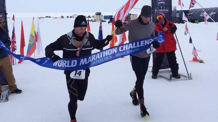 Captains Calum Ramm, left, and Daniel Cartica, right, cross a finish line during the World Marathon Challenge Jan. 23 at Union Glacier, Antarctica. The World Marathon Challenge is a seven-day event that encompasses seven marathons run on every continent. Cartica won the event with a cumulative time of 24 hours, 46 minutes and 56 seconds.