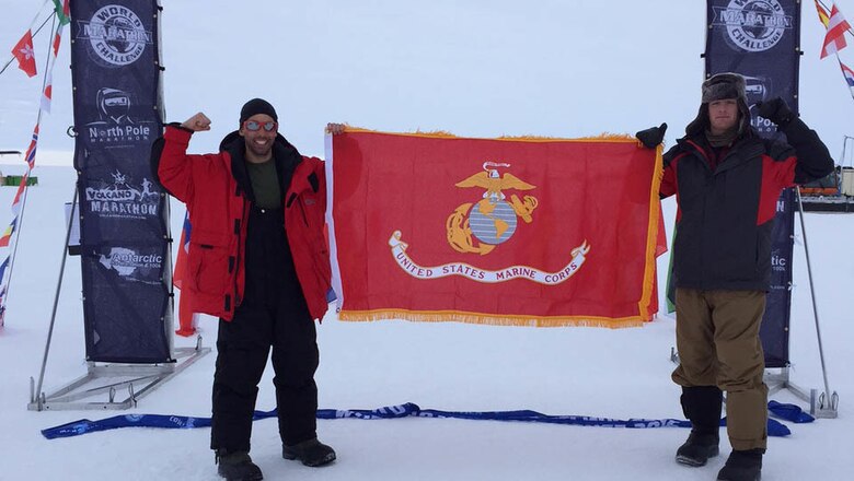 Captains Calum Ramm, left, and Daniel Cartica, right, hold the Marine Corps battle colors at the finish line during the World Marathon Challenge Jan. 23 at Union Glacier, Antarctica. The World Marathon Challenge is a seven-day event that encompasses seven marathons run on every continent. Cartica won the event with a cumulative time of 24 hours, 46 minutes and 56 seconds.