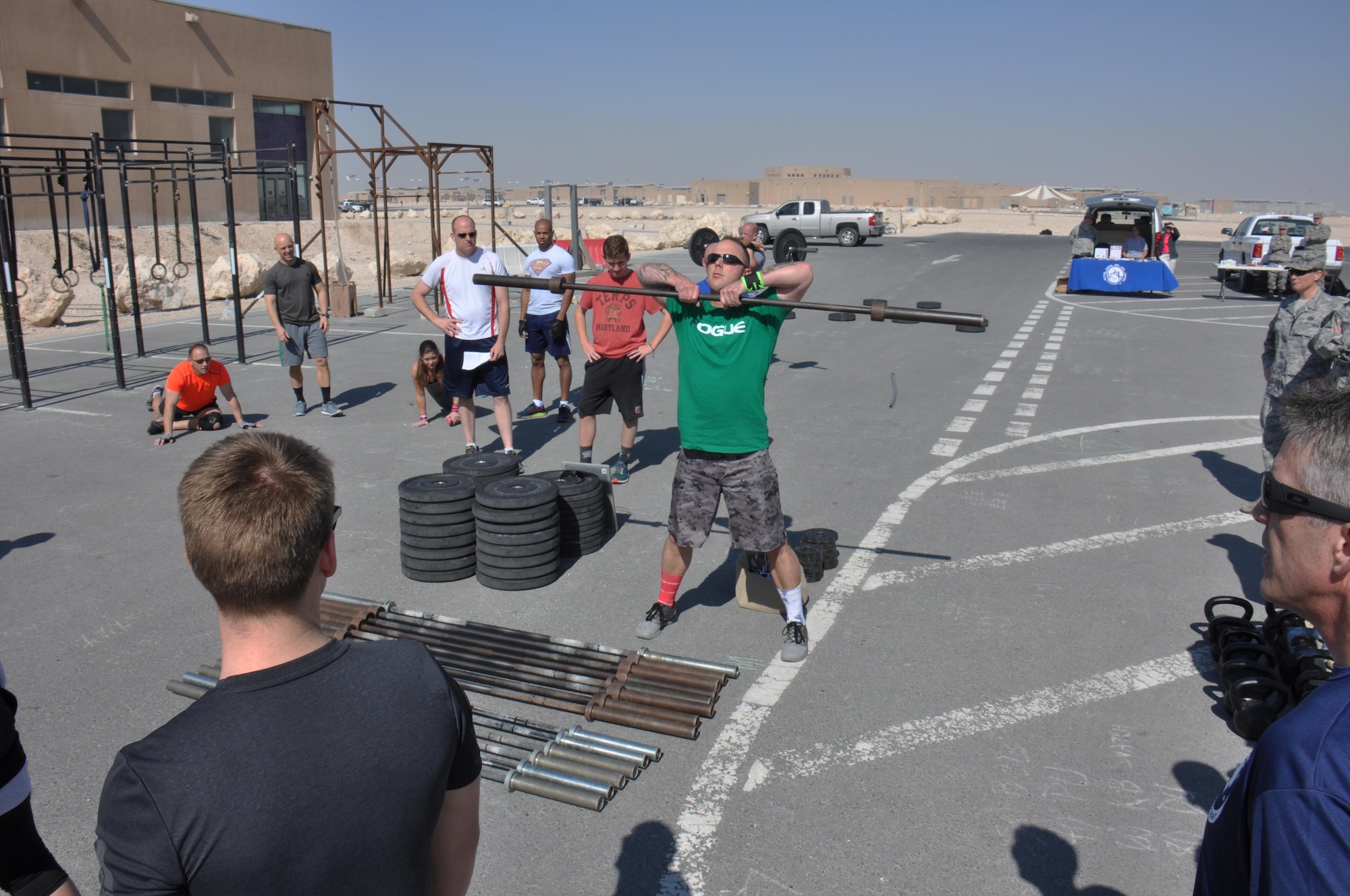 U.S. Army 1st Lt. Andy Larson, Combined Joint Task Force-Operation Inherent Resolve plans officer, demonstrates how to perform the clean exercise with a 45-pound barbell before the Cross Fit Undisclosed Suicide Awareness Workout at Al Udeid Air Base, Qatar, Feb. 6. More than 100 service members participated in the event, which was designed to bring more attention to Comprehensive Airmen Fitness with a focus on suicide prevention. The workout consisted of 22 different exercises and participants had to perform 22 reps of each exercise.  (U.S. Air Force photo by Tech. Sgt. James Hodgman/Released) 