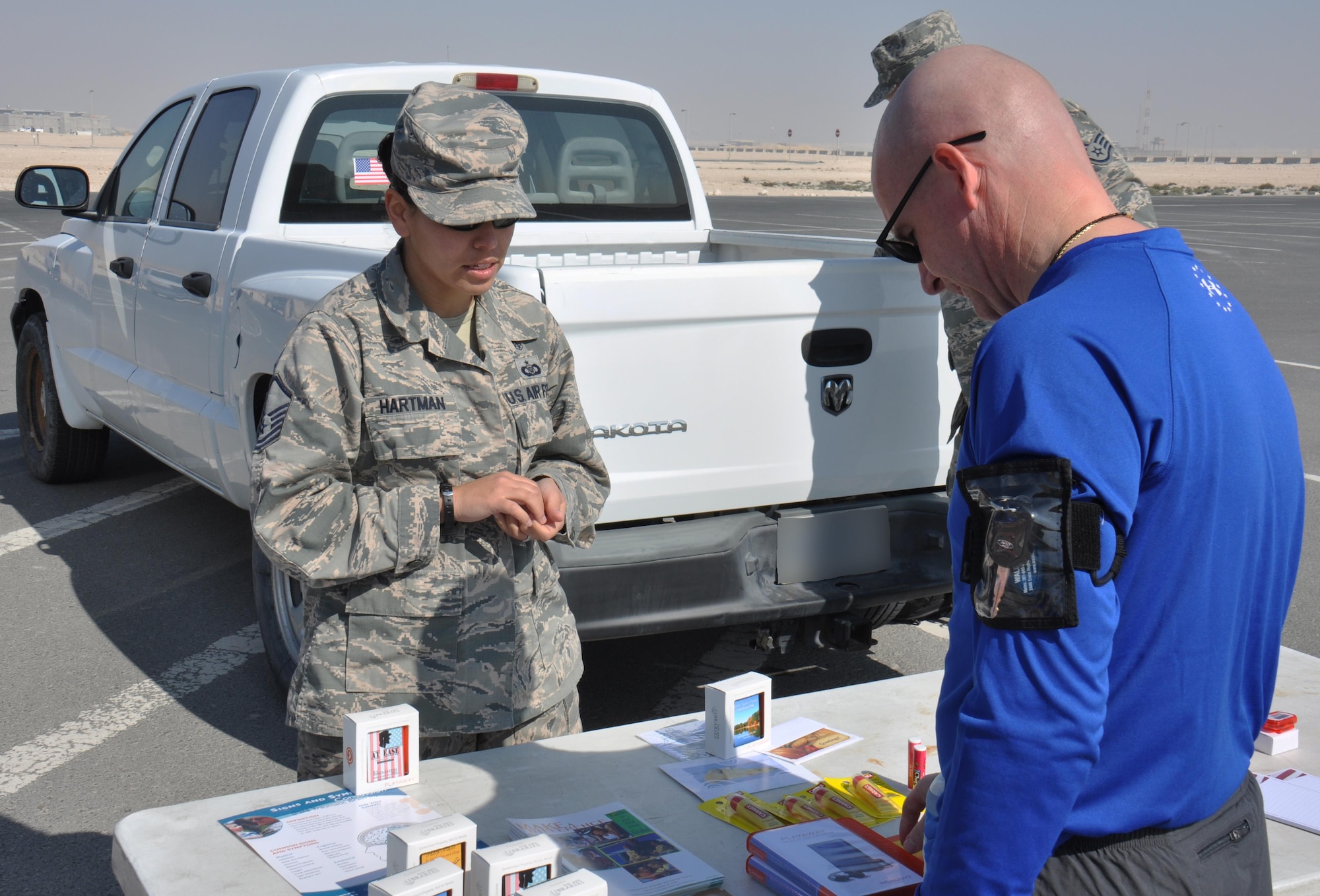 Master Sgt. Amy Hartman, 379th Expeditionary Medical Group Mental Health Clinic noncommissioned officer in charge, meets with Chief Master Sgt. Thomas Good, 379th Air Expeditionary Wing command chief, before the Cross Fit Undisclosed Suicide Awareness Workout at Al Udeid Air Base, Qatar, Feb. 6. Hartman provided relaxation tools to service members such as playaways and sleep masks. She also provided information on how to prevent anxiety, depression and suicide. Good joined more than 100 service members for the event, which was designed to bring more attention to Comprehensive Airmen Fitness with a focus on suicide prevention. Photo altered for security purposes. (U.S. Air Force photo by Tech. Sgt. James Hodgman/released)