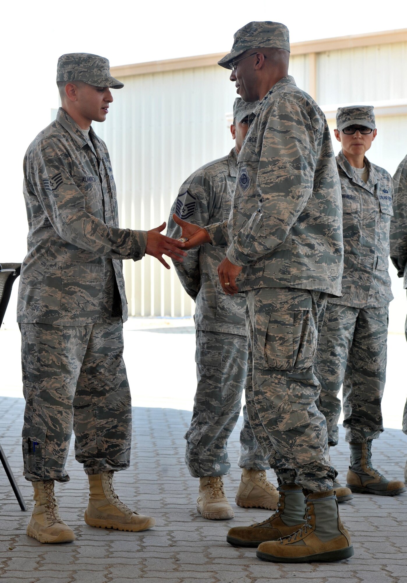 Lt. Gen. Charles Brown Jr., commander of Air Forces Central Command, presents a commander's coin to Staff Sgt. Ryan, 380th Expeditionary Operations Support Squadron, at an undisclosed location in Southwest Asia, Feb. 11, 2016. Brown visited the wing to congratulate the 380th on their operations leading up to the destruction of an Islamic State of the Levant banking facility during an airstrike in the month prior. (U.S. Air Force photo by Staff Sgt. Kentavist Brackin/released)