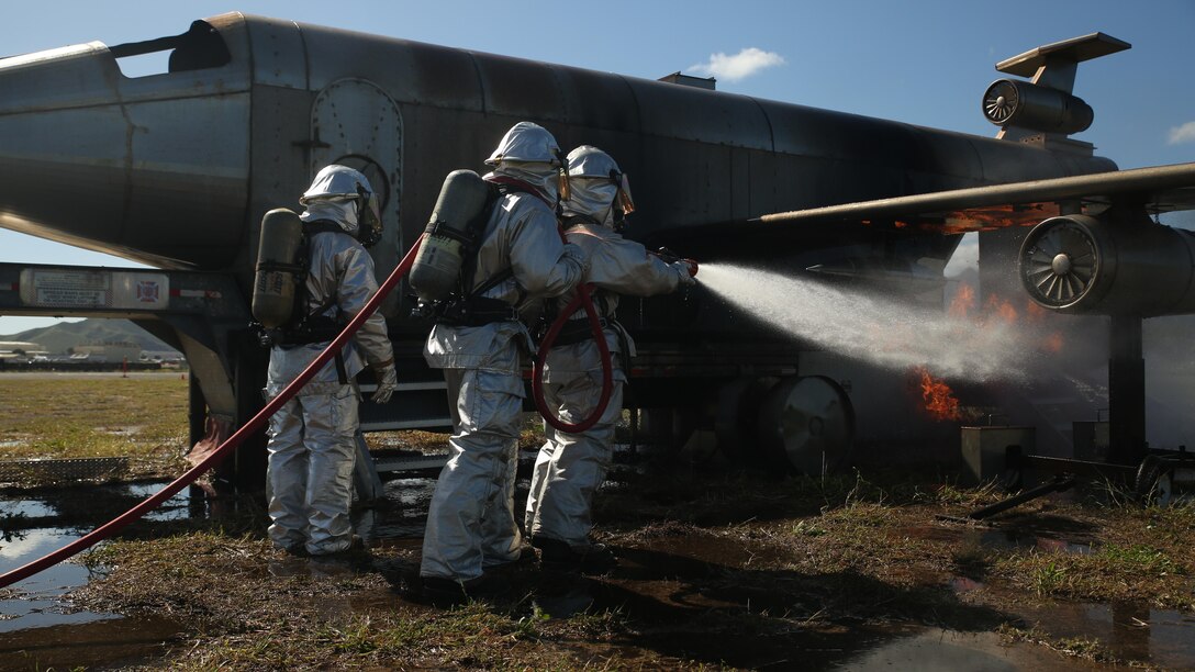 Marines with Air Rescue Fire Fighting train using fire suppression methods during burn training aboard Kaneohe Bay Marine Corps Air Station on Feb. 10, 2016. The mission of ARFF is to protect property and save lives, which means the Marines need to be suited up and moving out within seconds of a call. ARFF rescue men work together to prevent aircraft fires, house fires and any other emergency on the airfield and on base. 