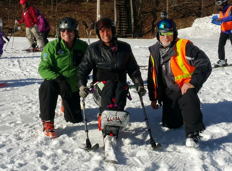Marcus Brumbaugh, (right) an electrical mechanic from the Nashville District poses with an adaptive skier and ski instructor during the 35th Disabled Sports USA Adaptive Learn to Ski event clinic held Jan. 19, 2016 at the Beech Mountain Resort in Beech Mountain, N.C. More than 300 people attended.   