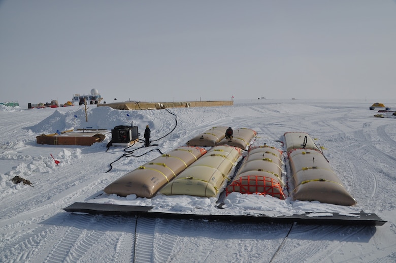 The ERDC-CRREL developed lightweight, high-efficiency fuel sleds greatly increase the amount of fuel delivered compared to traditional sleds and enable large cost savings and emissions reductions compared with air transport.  This image shows off-loading fuel delivered to Summit Station, Greenland, in 2011.