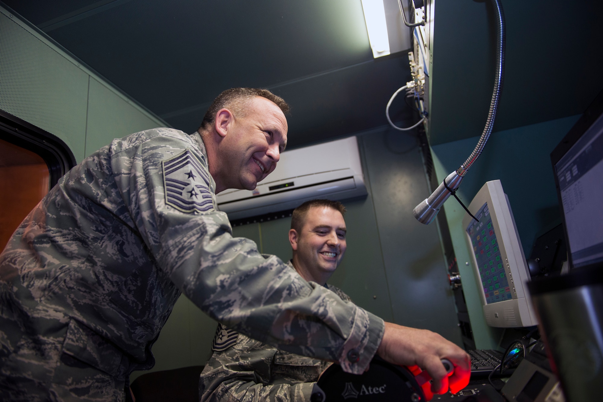 U.S. Air Force Chief Master Sgt. David Kelch, 23d Wing command chief, left, and Tech. Sgt. Dallas Morris, 23d Component Maintenance Squadron aerospace propulsion craftsman, share a laugh during a TF-34 engine run, Feb. 12, 2016, at Moody Air Force Base, Ga. Wing leadership visited the ‘hush house’, a building designed to test aircraft engines while significantly reducing noise output. (U.S. Air Force photo by Airman 1st Class Greg Nash/Released) 