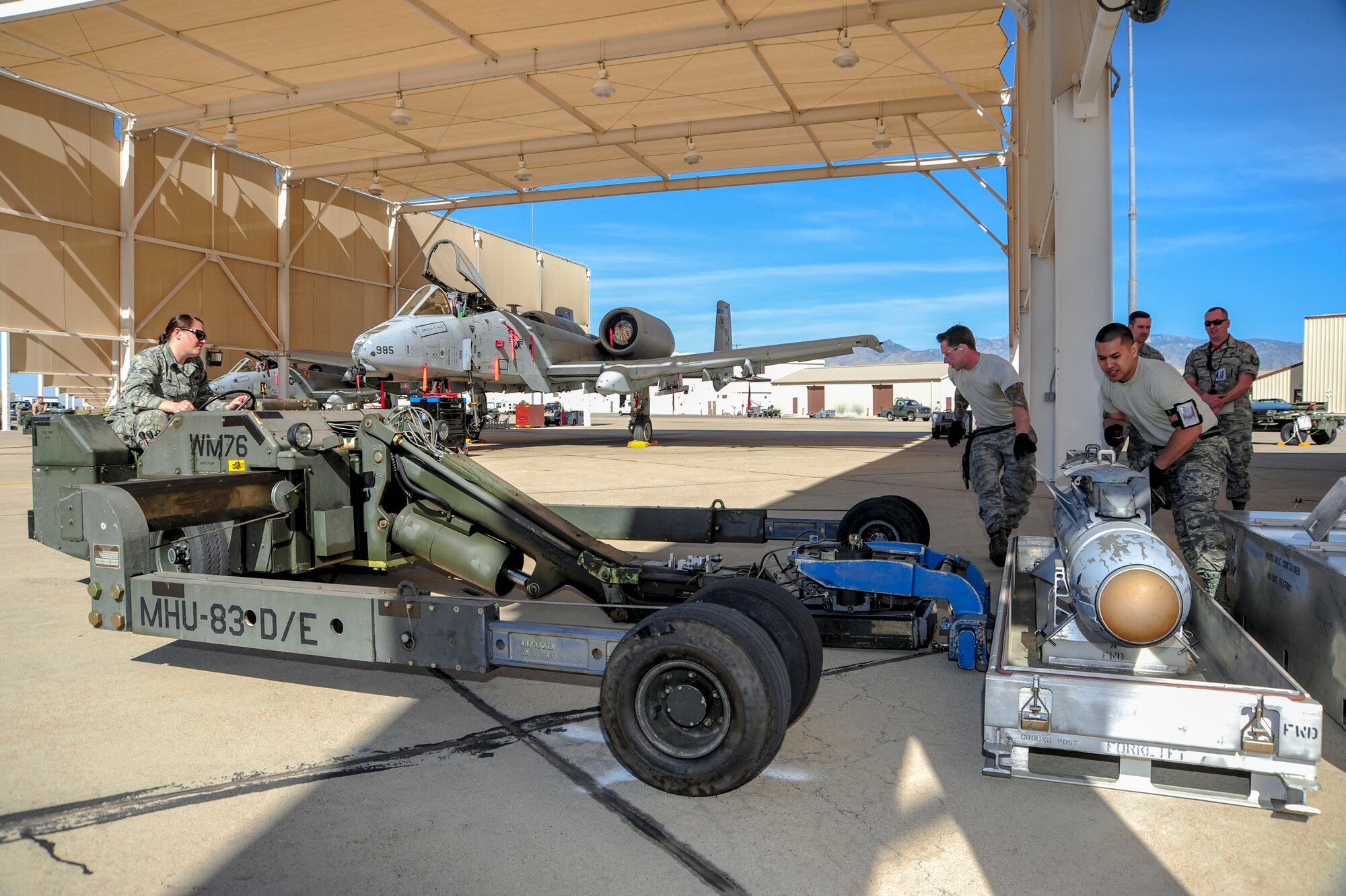 U.S. Air Force Senior Airman Bethany Lamb, Airman 1st Class Brett Sisk and Staff Sgt. Virine Salas, 354th Aircraft Maintenance Unit weapons load crew members, utilize an MHU-83 bomb loader to load an AGM-65 Maverick missile onto an A-10C Thunderbolt II during a load crew of the year competition at Davis-Monthan Air Force Base, Ariz., Feb. 5, 2016. The load crews that participated in this year’s LCOY competition were winners of last year’s load crew of the quarter competitions. (U.S. Air Force Photo by Senior Airman Chris Massey/Released)
