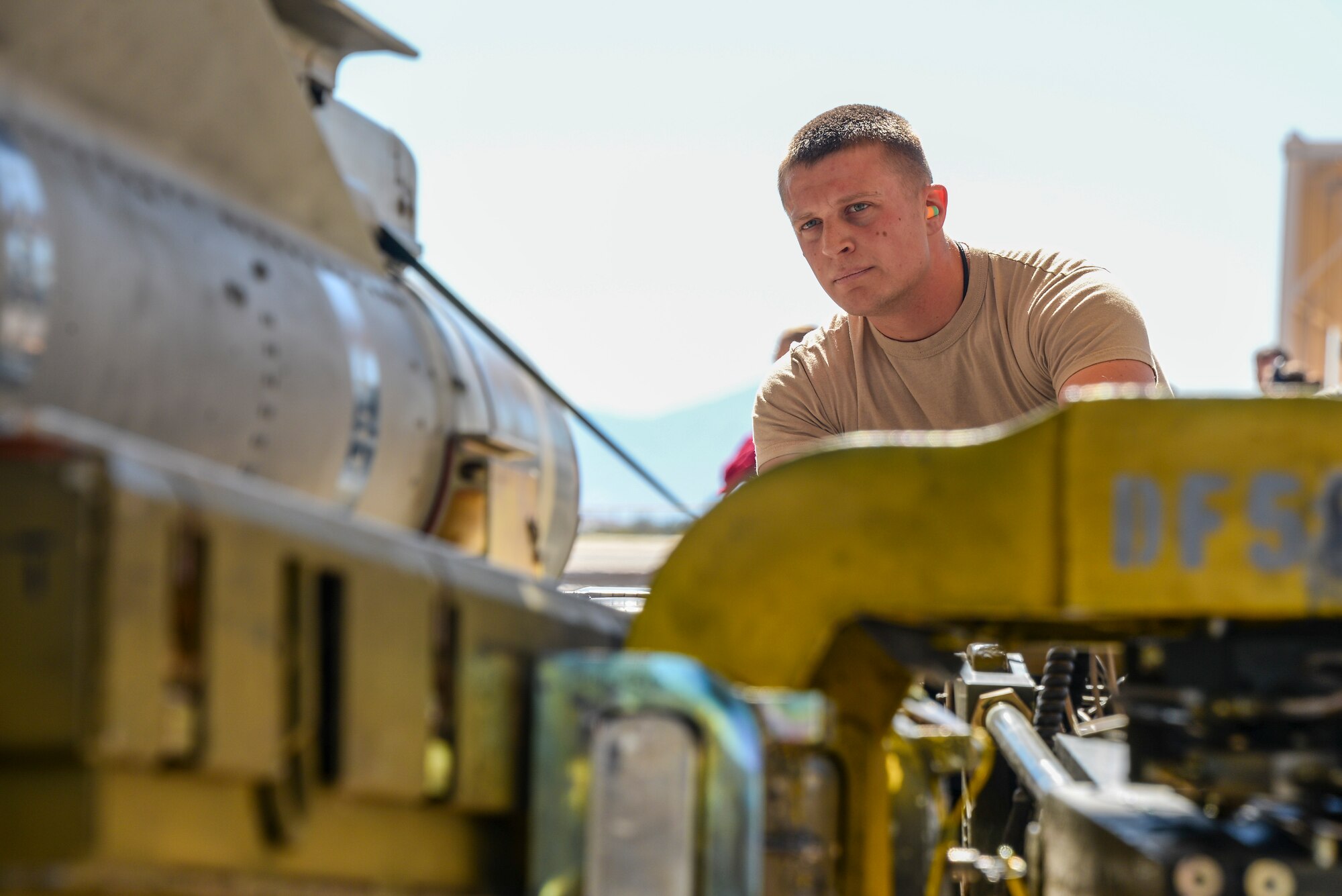 U.S. Air Force Senior Airman John Clarke, 355th Aircraft Maintenance Squadron weapons load crew member, drives  an MHU-83 bomb loader to load an AGM-65 Maverick missile onto an A-10C Thunderbolt II during a load crew of the year contest at Davis-Monthan Air Force Base, Ariz., Feb. 5, 2016. Four load crews assigned to the 354th AMU and 355th AMXS competed against each other. (U.S. Air Force photo by Airman 1st Class Mya M. Crosby/Released)