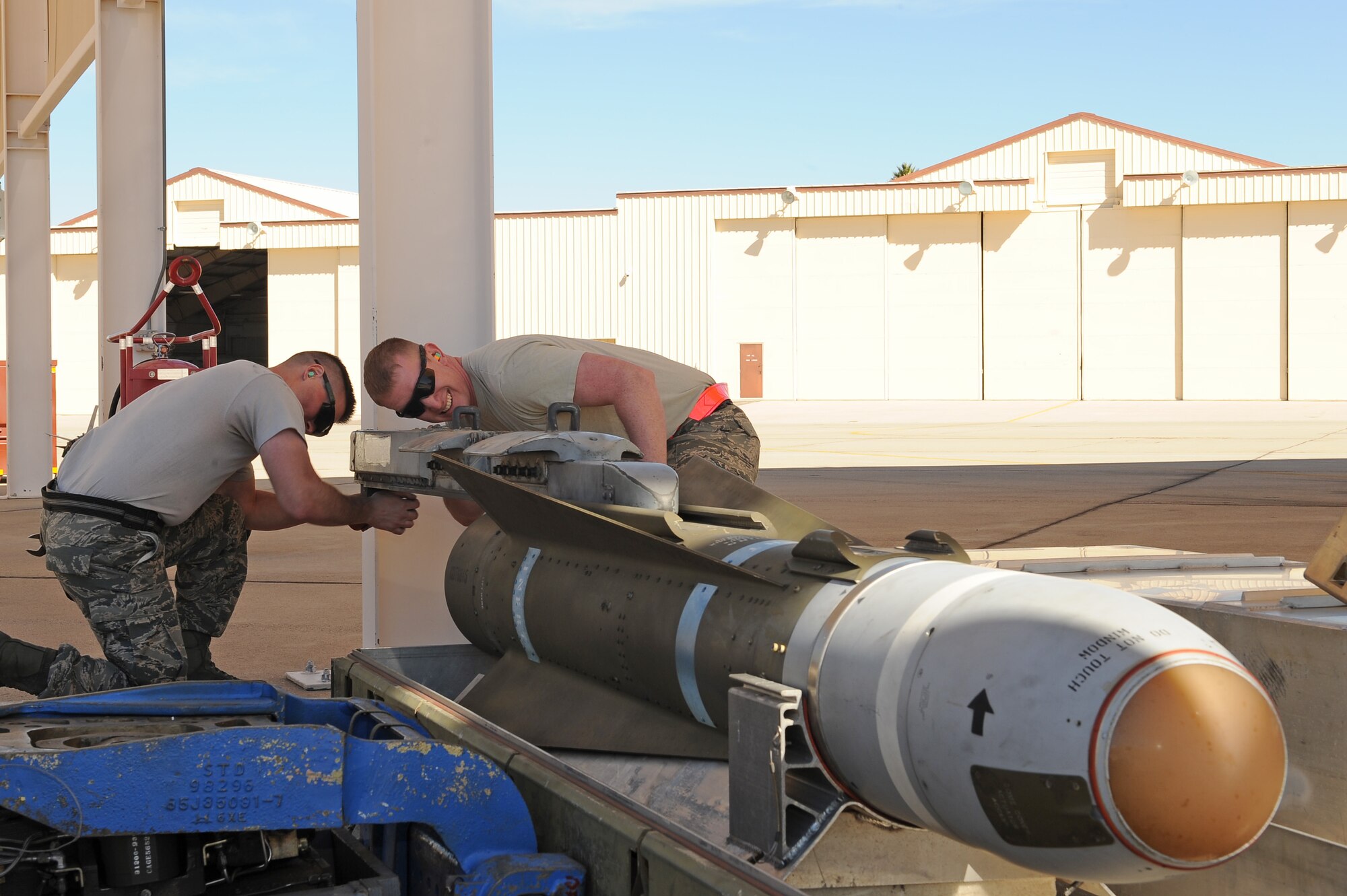 U.S. Air Force Staff Sgt. Riley Whittaker, 354th Aircraft Maintenance Unit weapons load crew chief, and Senior Airman Nathanial Awrey, 354th AMU weapons load crew team member, prepare an AGM-65 Maverick missile to be loaded onto an A-10C Thunderbolt II during a load crew of the year competition at Davis-Monthan Air Force Base, Ariz., Feb. 5, 2016. The load crews were evaluated on timeliness and deficiencies during the contest. (U.S. Air Force photo by Senior Airman Cheyenne A. Powers/Released)