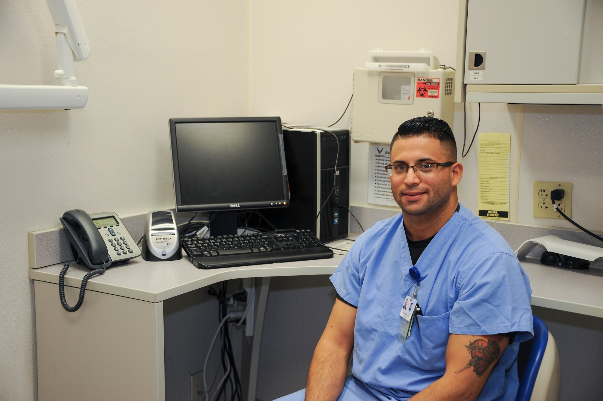 Ivan Grijalva, 355th Dental Squadron dental assistant, sits at a desk in the dental clinic at Davis-Monthan Air Force Base, Feb. 11, 2016. Grijalva used his knowledge from how he constricts blood flow with bands when starting IVs at work to apply a tourniquet to stop the bleeding of a motorcycle accident victim. (U.S. Air Force photo by Airman 1st Class Ashley N. Steffen/ Released)