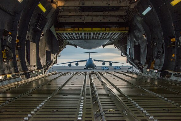 A C-5 Galaxy is framed by the opened aft cargo door of another C-5 Super Galaxy Feb.  4 at Travis Air Force Base, California. Travis recently completed Crisis Look 16-0, an operational readiness inspection designed to evaluate how quickly personnel base wide can mobilize and move people, heavy equipment and whatever else is needed to anywhere in the world at a moments’  notice when called upon in an emergency situation. (U.S. Air Force photo by Heide Couch)