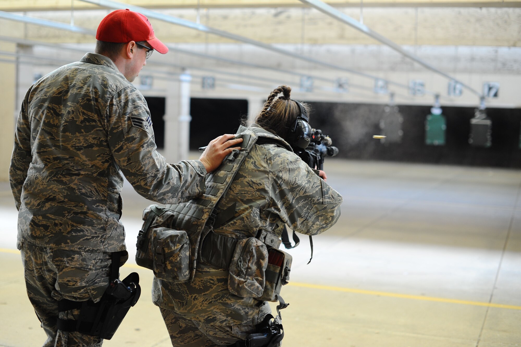 Senior Airman Robert McNabb, 184th Security Forces Squadron combat arms instructor, guides Senior Master Sgt. Stacie Smith, 184th SFS superintendent, on which targets to engage during an annual qualification course, Feb. 12, 2016, at McConnell Air Force Base, Kan. Annual qualifications are necessary to maintain marksmanship and familiarity with firearms techniques. (U.S. Air Force photos/Airman 1st Class Christopher Thornbury)