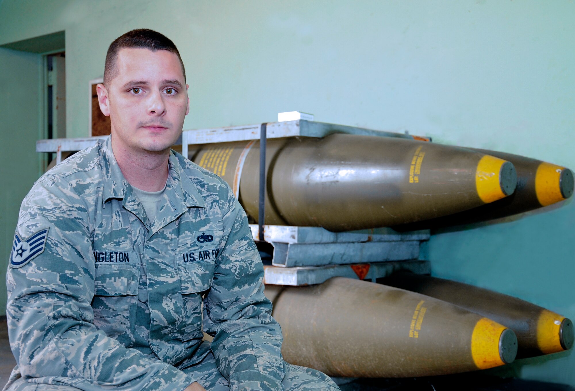 Staff Sgt. Robert Singleton, the NCO in charge of munitions operations with the 6th Maintenance Squadron (MXS), pauses for a photo next to munitions Jan. 14, 2016 at MacDill Air Force Base, Fla. Singleton received the 2015 Air Mobility Command (AMC) Munitions Maintenance Technician Supervisor award. (U.S. Air Force photo illustration by Senior Airman Jenay Randolph) 