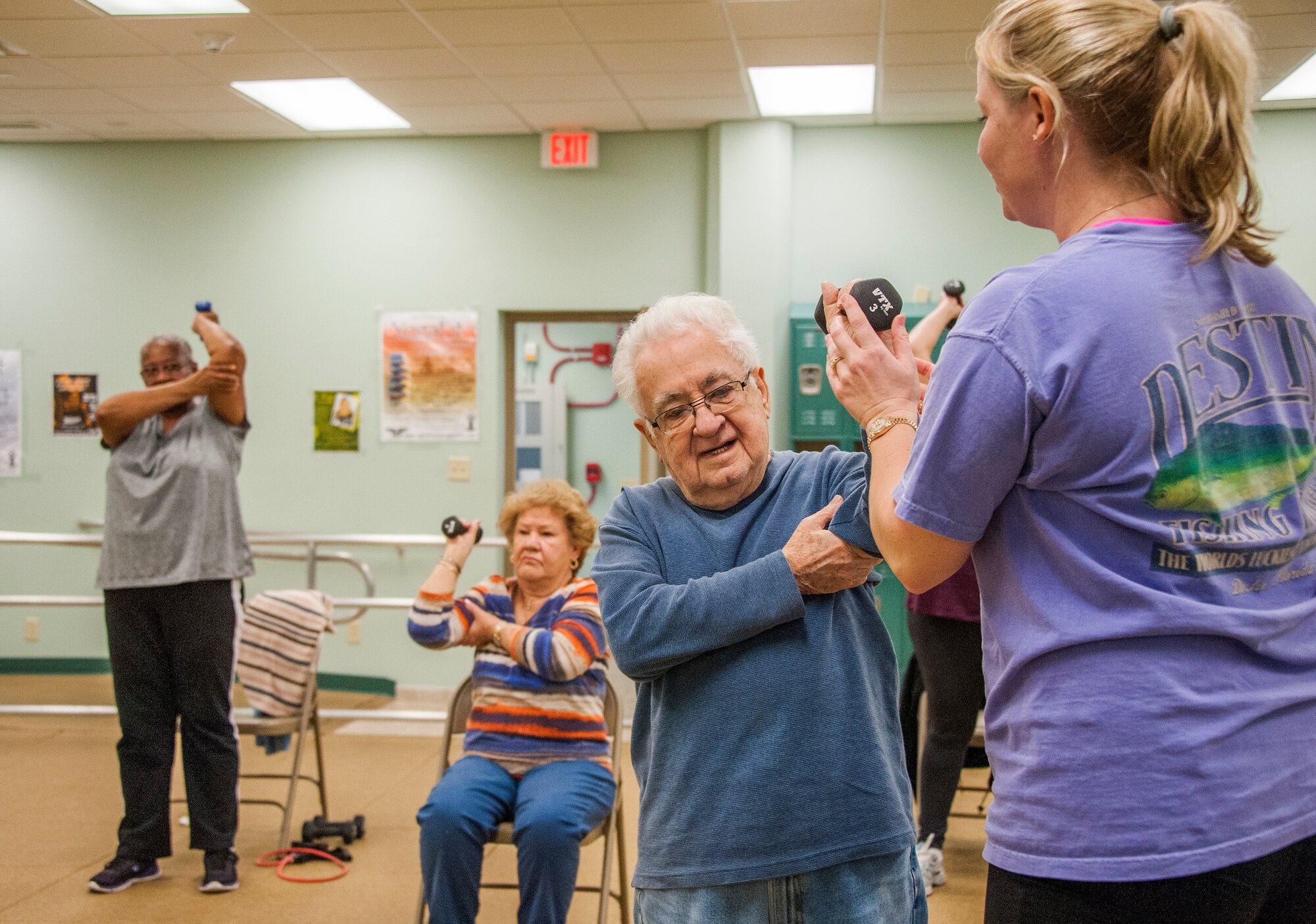 Nicole Sisk, 96th Medical Group clinical health promotion coordinator, helps Frank Acosta with his tricep extension during an exercise session Feb. 4 in Building 720 at Eglin Air Force Base, Fla. Go4Life is an eight-week program that builds strength, balance and flexibility. The program also encourages sedentary, older adults to make health improvements by making physical activity a part of their daily routine. (U.S. Air Force photo/Ilka Cole)
