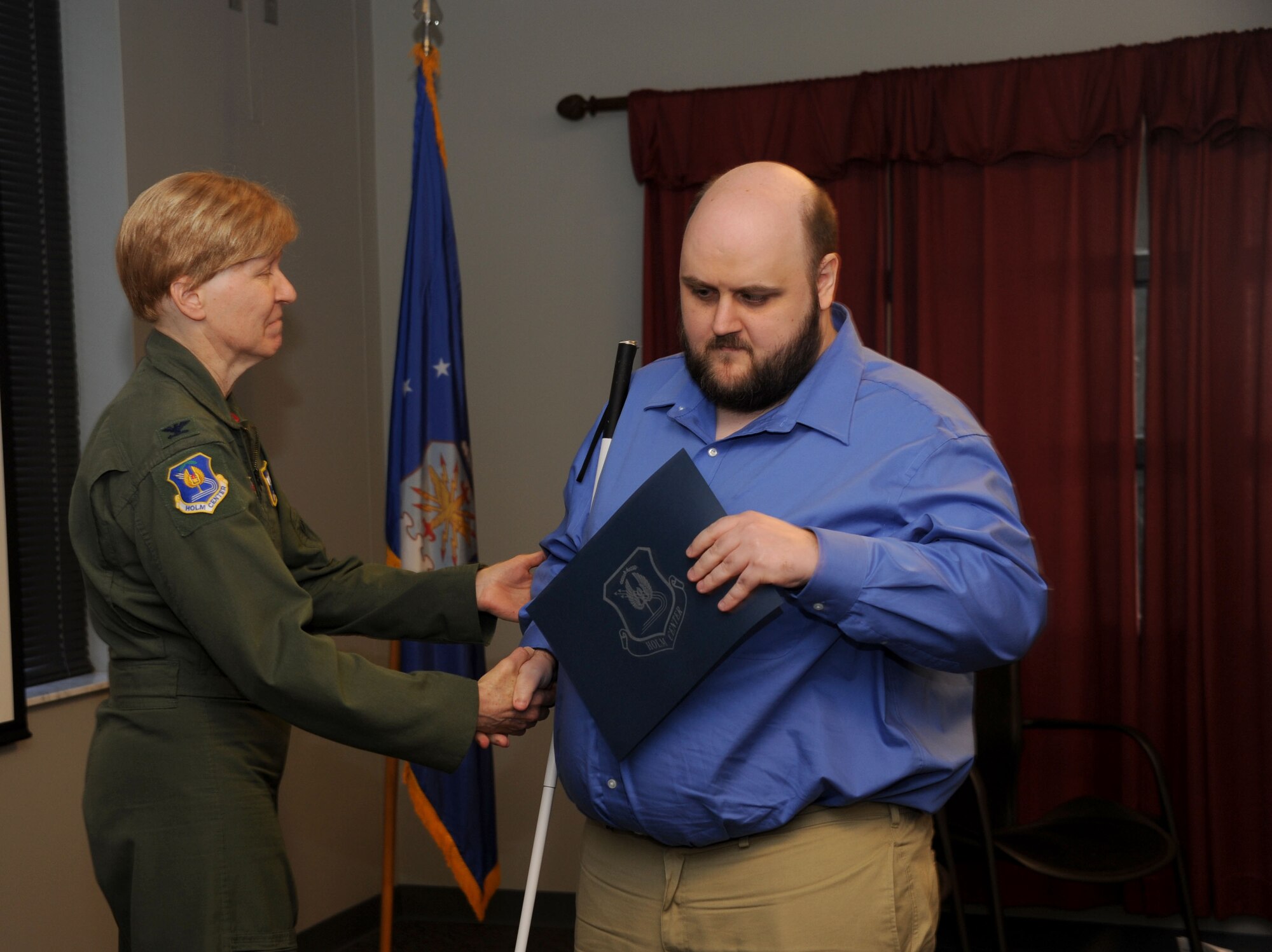 Joseph Lininger, Civilian Acculturation and Leadership Training student, receives his graduation certificate from Col. Patricia Hoffman, vice commander of the Jeanne M. Holm Center for Officer Accessions and Citizen Development, during the CALT graduation of class 16-03 Feb. 5, 2016, at Maxwell Air Force Base, Alabama. Lininger was the first blind student to attend and graduate from the CALT course. (U.S. Air Force photo by Airman 1st Class Alexa Culbert)