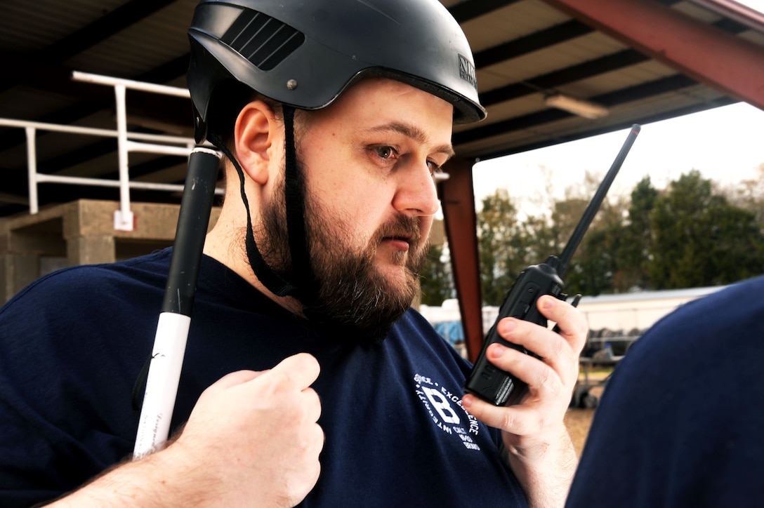 Joseph Lininger, Civilian Acculturation and Leadership Training student, guides his classmates using a radio as they maneuver through a Project X obstacle Feb. 2, 2016, at Maxwell Air Force Base, Alabama. Because he is blind, he was not able to physically participate in the obstacles. However, Lininger guided his classmates by playing the part of a commanding officer who is not physically with his unit. (U.S. Air Force photo by Airman 1st Class Alexa Culbert)