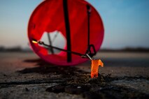 A distance marker is held in position on an unimproved surface during an austere landing exercise at Plovdiv, Bulgaria, Feb. 9, 2016. The colorful markers were put in place by 321st Special Tactics Squadron combat controllers and are used as a visual reference point to aid pilots when landing on unmarked surfaces. (U.S. Air Force photo by Airman 1st Class Luke Kitterman/Released)