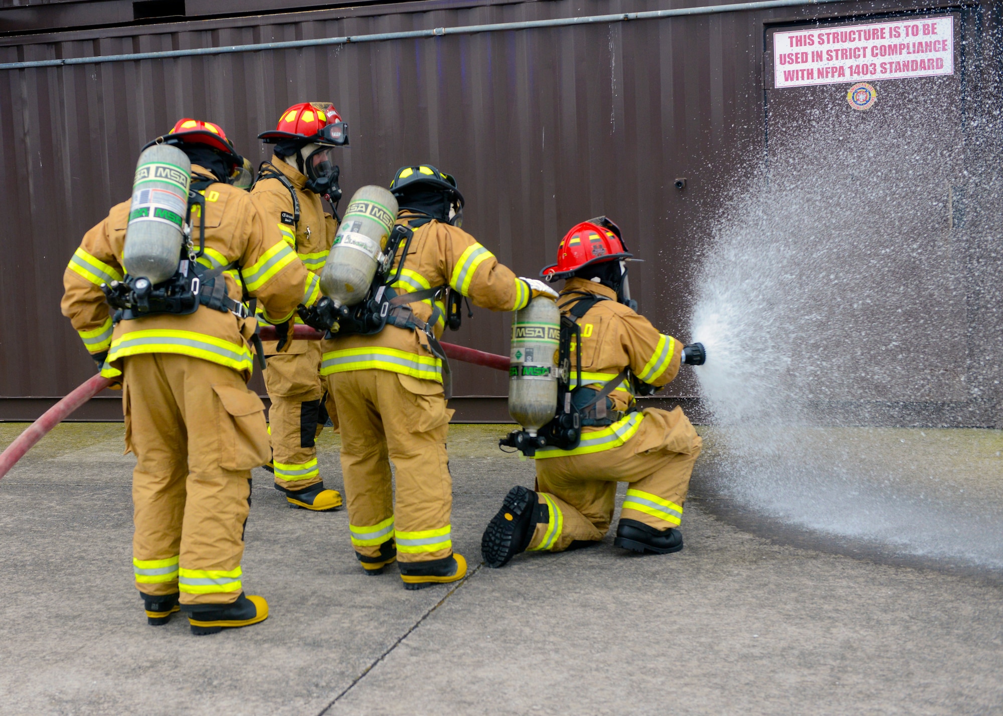 Firefighters from the 65th Civil Engineer Squadron tests a fire hose before combatting a structural fire at their training facility on Lajes Field, Azores, Feb. 6, 2016. The training was designed to prepare newly hired Portuguese locals. Lajes Field, operated by the 65th Air Base Group, became a geographically separated unit of the 86th Airlift Wing in August, 2015. (U.S. Air Force photo/Tech. Sgt. Kristopher Levasseur)