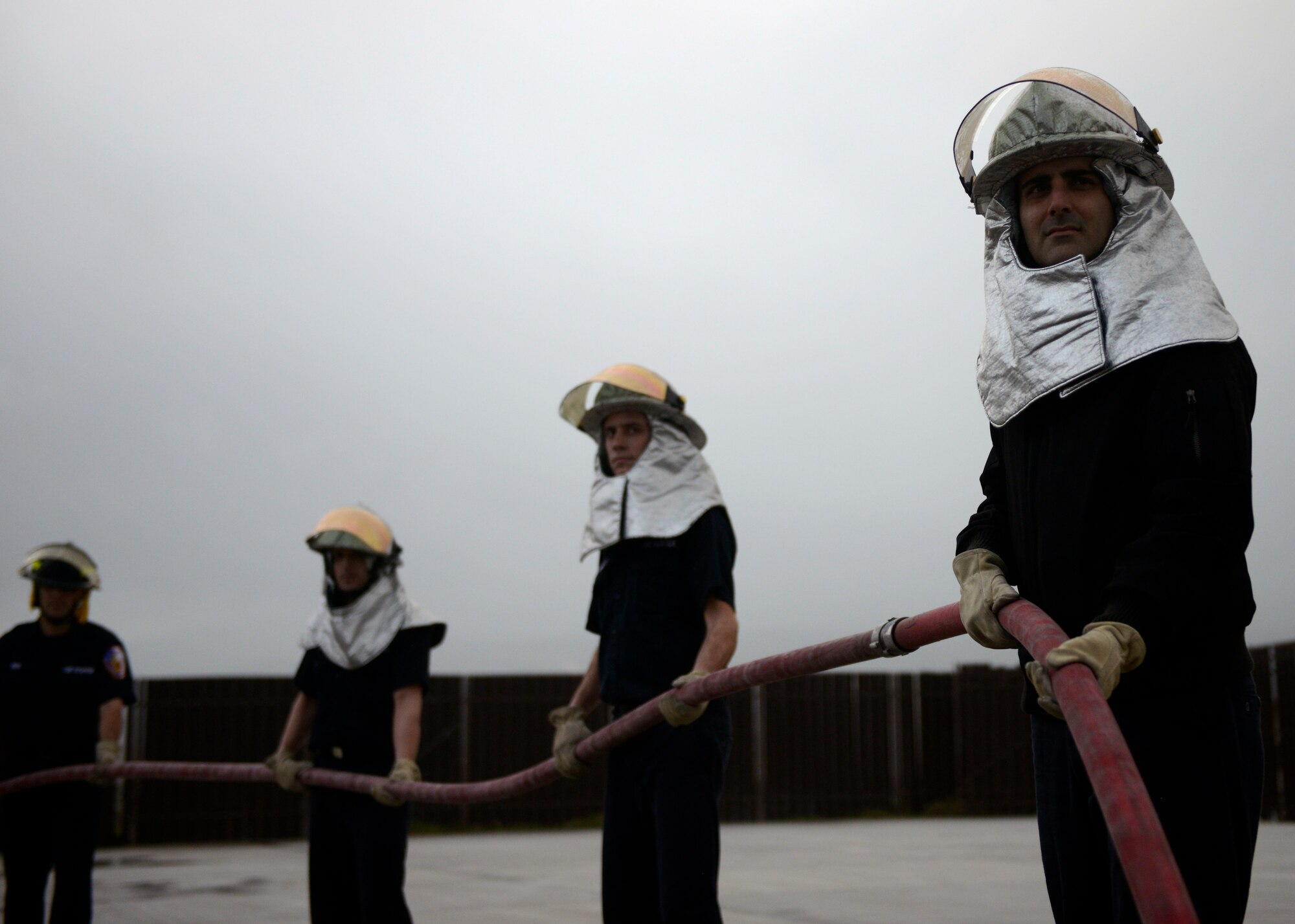 Newly recruited firefighters from the 65th Civil Engineer Squadron support a fire hose for their classmates while they combat a structural fire at their training facility on Lajes Field, Azores, Feb. 6, 2016. The training was designed to prepare newly hired Portuguese locals. Lajes Field, operated by the 65th Air Base Group, became a geographically separated unit of the 86th Airlift Wing in August, 2015. (U.S. Air Force photo/Tech. Sgt. Kristopher Levasseur)