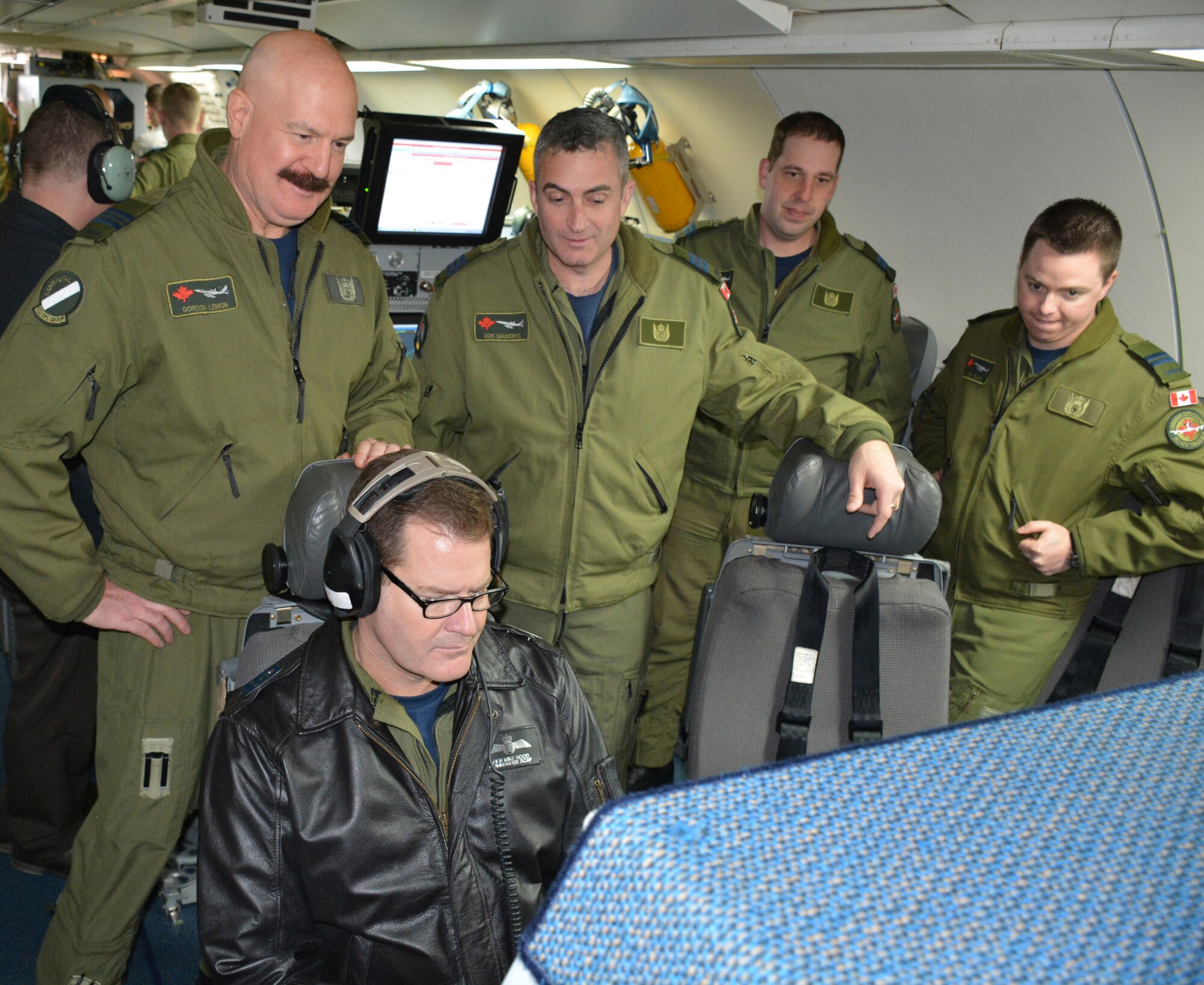 Lt. Gen. Mike Hood, commander of the Royal Canadian Air Force, seated, listens to a recording of a recent mission performed by members of the 552nd Air Control Wing during a tour of an E-3 “Sentry” Airborne Warning and Control System Block 40/45 aircraft on Feb. 3 at Tinker Air Force Base. Looking over the general’s shoulder and taking part in the E-3 static display are, from left, Maj. Gordon Lemon, mission crew commander; Lt. Col. Donald Saunders, 552nd ACW Canadian Detachment commander; Capt. Andrew Baier, airborne surveillance officer; and Capt. Anthony Snow, senior director. General Hood, assigned to the National Defense Headquarters in Ottawa, visited with the Canadian Detachment that consists of 39 members of the Royal Canadian Air Force and three members of the Canadian Army. During his visit, the general also met with Col. David Gaedecke, 552nd ACW commander, and held a commander’s call with members of the detachment. The partnership between the Canadian Detachment, which falls under the 552nd ACW, is now in its 36th year. The Detachment first began working with the 552nd ACW in 1979. (Air Force photo by Darren D. Heusel/Released)