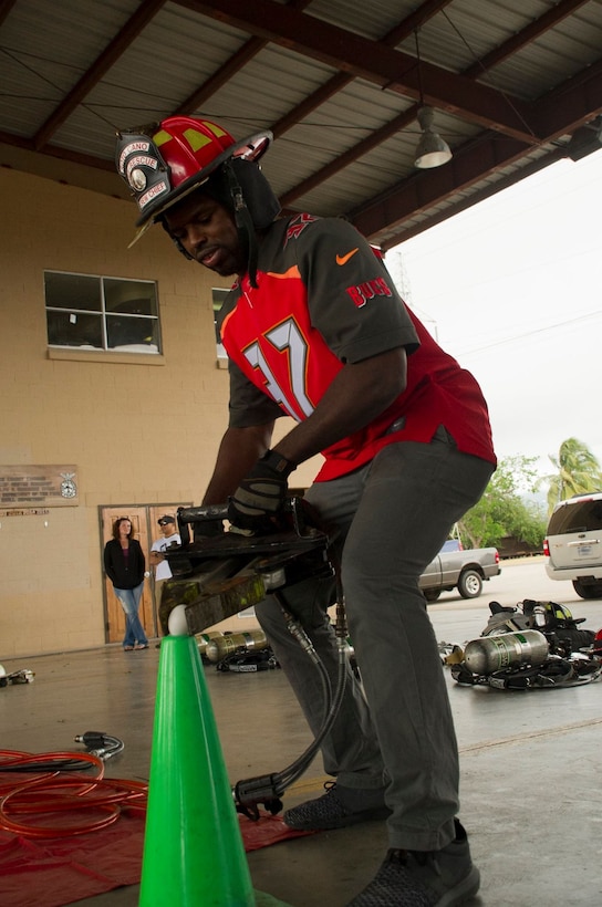 Keith Tandy, Tampa Bay Buccaneers safety attempts to pick up an egg to demonstrate the precision and dexterity of a devise emergency responders use to manipulate metal and other materials Feb. 7, 2016 at Soto Cano Air Base, Honduras. NFL cheerleaders and players took time to meet with members of the base as a part of a visit to the base hosted by the Armed Forces Entertainment for Super Bowl 50. (U.S. Air Force photo by Capt. Christopher Mesnard/Released)